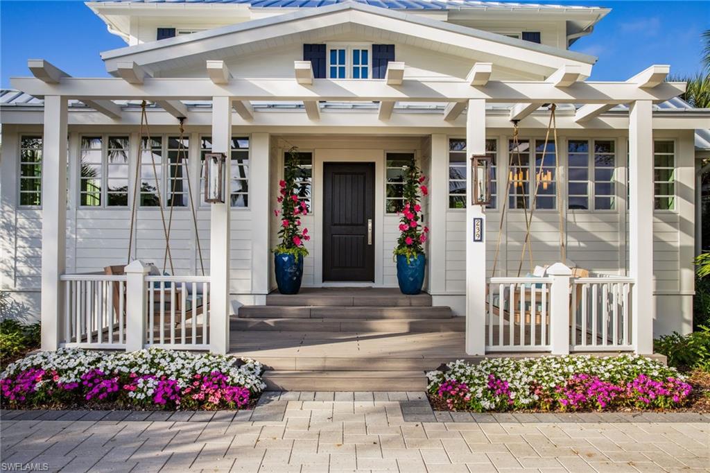 **Welcome to Timeless Elegance in Old Naples**  Step into this beautifully reimagined 1940s cottage, where classic charm meets modern luxury. Located in the heart of historic Old Naples, this fully furnished home effortlessly combines vintage allure with contemporary sophistication. Designed by MHK Architecture, this home offers 4,803 sq. ft. of meticulously crafted living space. With four spacious en-suite bedrooms and a study, the property is perfect for both relaxation and entertainment. The VIP suite stands out as a private oasis, complete with its own guest living area and a separate entrance for added exclusivity. Inside, you’ll find elegant white oak floors, a cypress stained tongue-and-groove ceiling, and a stunning white oak staircase. The gourmet kitchen is outfitted with premium Miele, Sub-Zero, and Wolf appliances, while expansive Euro doors create a seamless transition between indoor and outdoor living.
Outside, unwind in your private retreat—a saltwater pool with a serene waterfall, surrounded by a lush living wall. The property also features a 3 car garage with an added space for a golf cart and alley access for convenience and guest parking. Fully updated with a new foundation, impact windows, a second floor creating expanded living areas. This home is the perfect blend of timeless elegance and modern comfort. Watch our lifestyle video to explore this exceptional residence and its breathtaking surroundings! Originally constructed in 1940, this home has undergone a comprehensive renovation and received its Certificate of Occupancy in 2024. The home has remained dry thru Hurricane Ian and any storm thereafter . Water never reached the first floor or the pool deck.