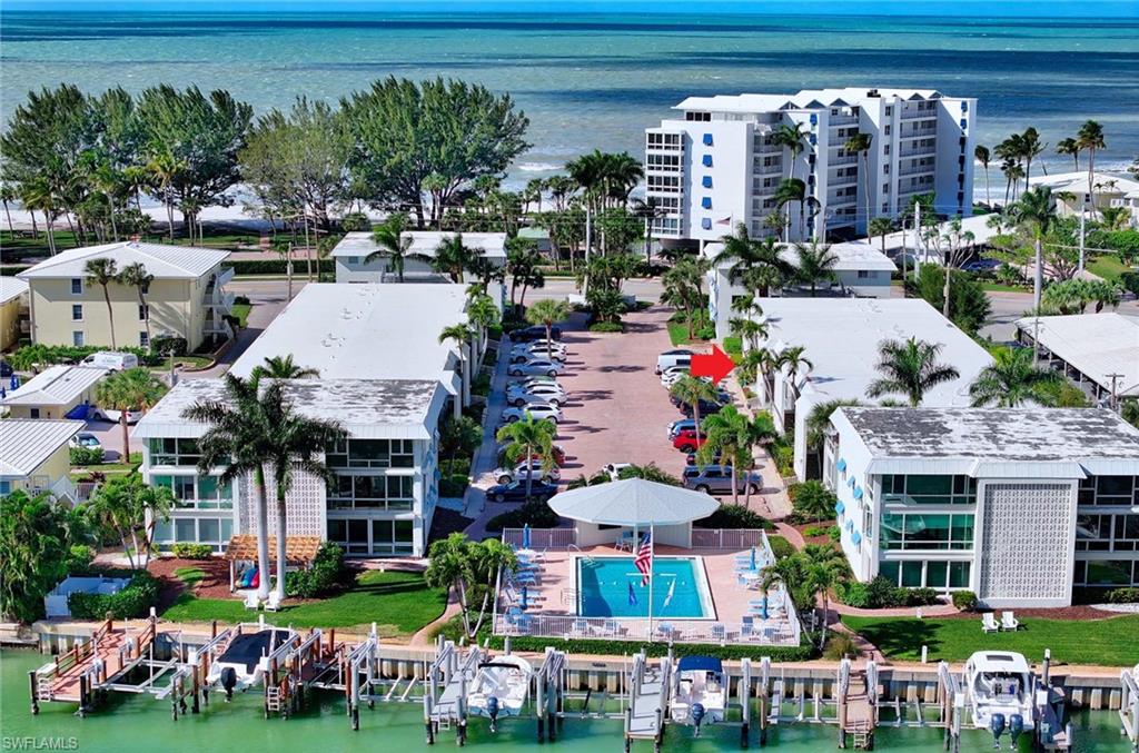 Welcome to "Miracle Mile".  Completely transformed with an effortless coastal aesthetic and offered furnished, this 2 bed, 2 bath residence presents an exceptional opportunity to enjoy one of Naples' most desirable waterfront locations. Situated directly across from the Gulf of Mexico and overlooking the bay, the home combines the best of beachside and boating lifestyles within the peaceful, intimate setting of the boutique Port au Villa community. The interior showcases new flooring, updated appliances, sleek designer finishes, and fully reimagined baths. The open-concept kitchen serves as the heart of the home, featuring expansive quartz surfaces, generous island seating, and a seamless connection to the living room. Natural light fills the interiors, creating a bright and inviting atmosphere throughout. Residents enjoy a bayside pool with sweeping water views, grilling area, bike storage, assigned parking, additional storage, and the convenience of an in-unit washer and dryer. Owners are also eligible to join The Moorings Property Owners Association (MPOA), providing access to the private Moorings Beach Park, where members enjoy one of Naples' most coveted beachfront settings complete with Gulf-front beach access, parking, and breathtaking sunset views. Ideally positioned just minutes from The Naples Beach Club/Four Seasons, Venetian Village, Olde Naples, Fifth Avenue South, and some of Southwest Florida's finest dining and shopping destinations, this residence captures the essence of the Naples lifestyle—where beach walks, boating excursions, waterfront sunsets, and world-class amenities are part of everyday life.