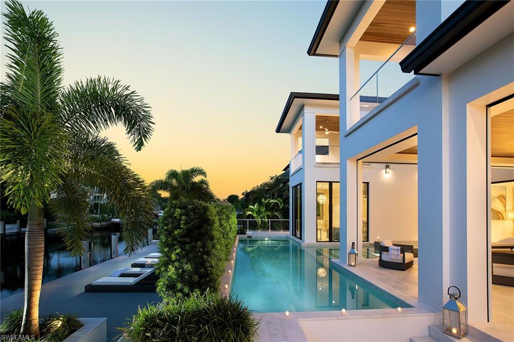 Remarkably detailed and elegant in every way, this new construction gem is ideally situated in the coveted southern point of Aqualane Shores. Enter in through the impressive glass double doors and be drawn to the two-story great room, highlighted by high impact Andersen windows and sleek solid white glass flooring, providing a neutral and maintenance-friendly backdrop. Custom millwork with geometric designs is the focal point for the dining area and perfectly divides the kitchen and family room to its own intimate space. Full inset kitchen cabinetry with solid walnut interiors are luxurious and surround the two 30-inch wall ovens, custom Wolf cooktop and island with white marble waterfall countertops. Seamlessly opening to the family room, residents and guests will enjoy sitting by the linear 60-inch fireplace or in the covered lanai area just outside the Weiland sliders, providing the ease of no thresholds. No detail is spared in this one of a kind retreat from the spacious and quiet master suite, guest’s and owner’s laundry rooms and private elevator to the expansive outdoor area with Azek dock, custom mahogany outdoor kitchen and 20kW generator.