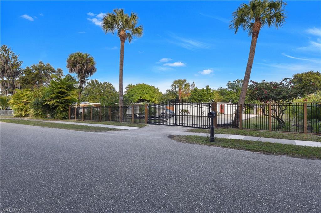 RARE FIND - wonderful home w/ diverse use! This property offers MORE than most in area- completely gated, main home w/ 2 suites, gourmet kitchen (w/ cooktop & convection microwave & wall oven), tile flooring throughout, guest house efficiency w/ 1/1, carport area, and massive open lanai. The home is piped for gas if desired and features a wood burning fireplace, sliding barn door on walk-in closet in master suite, frameless shower enclosure in guest suite, and comfortable layout for growing family. Russell Park is a non-gated, NO HOA fee community that has quick access to I-75 & Palm Beach Blvd taking you straight to the East Coast, plus only a short drive to the redeveloped Fort Myers River District.