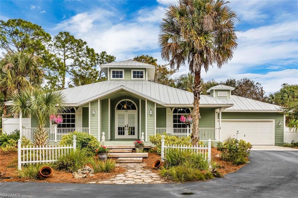 Calling all nature lovers!! Relaxing and serene home surrounded by lush and succulent landscaping, white picket fence with over 2 acres of cleared land…yes, you have just found your home in tropical paradise!  
This Key West cottage style home is nestled in the estates; however, conveniently located close to Collier Blvd. where you’ll find the new Founder’s Square, Mission Hills Shopping Center, and 15 miles to Naples beaches. Step up to the wooden deck and front patio as you enter through the French doors. The inside has high ceilings as you enter the home with transom windows above to bring the outside in. 3 bedrooms and 2 bathrooms (One bedroom offers an office area with a convenient hideaway bed and built in shelving).  The Kitchen has white cabinetry with single lite glass doors and GE appliances. The living room has an electric fireplace to enjoy the ambiance of country style living. Perfect for pet lovers as the floors are a combination of wood and tile throughout with a fenced in backyard. You won’t want to miss this opportunity to own a piece of Naples property!