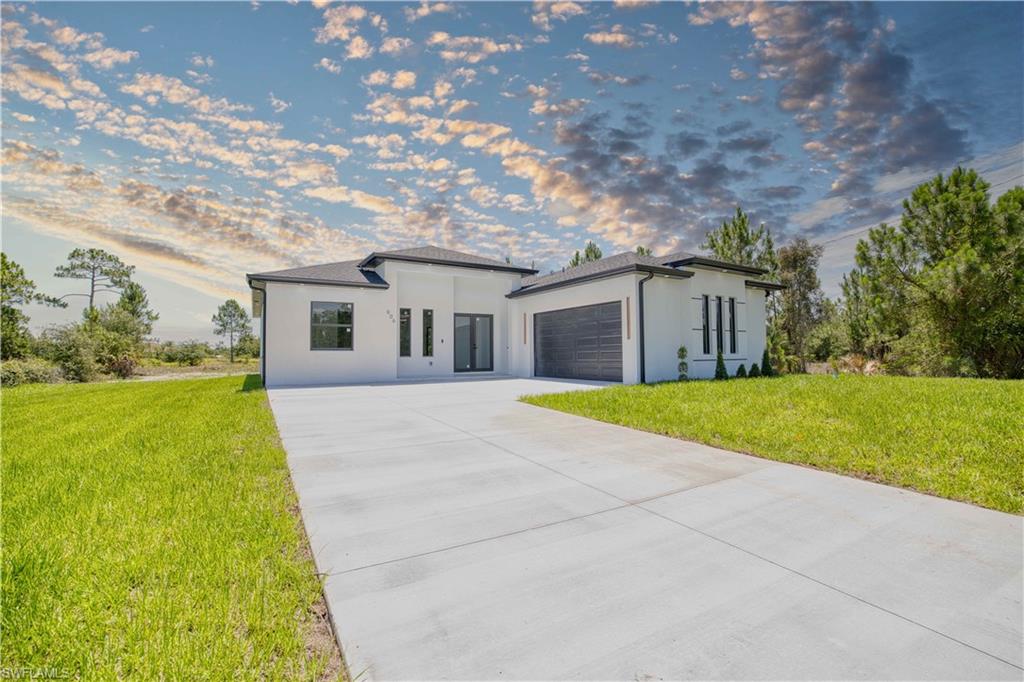 Brand-new construction on a spacious ½-acre lot in the growing community of Lehigh Acres! This beautifully designed home offers 1,866 sq. ft. of living area and 2,605 total sq. ft., featuring 4 bedrooms, 3 bathrooms, and a 2-car garage. The open-concept floor plan is highlighted by a custom-designed kitchen with premium finishes, perfect for entertaining and everyday living. Enjoy the convenience of a dedicated laundry room, impact-resistant windows and doors for added security and energy efficiency, and a spacious full patio ideal for relaxing or creating your dream outdoor living area. Built with quality craftsmanship and modern finishes throughout, this move-in-ready home is conveniently located near schools, shopping, dining, and major roadways. Don't miss the opportunity to own this exceptional new construction in one of Lehigh Acres' fastest-growing neighborhoods.