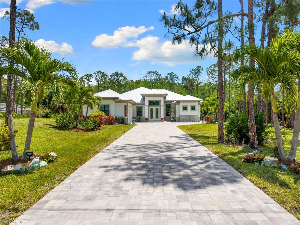 STUNNING 2020 CUSTOM-BUILT LUXURY POOL ESTATE SET ON A SPRAWLING 1.25-ACRE LOT IN BONITA SPRINGS’ COVETED “SAN CARLOS ESTATES!” Enjoy SERENE WOOD VIEWS, exceptional privacy, and a true sense of nature. This contemporary residence showcases an impressive OPEN FLOOR PLAN with 2,304 square feet under air, offering 4 bedrooms, 3 bathrooms, a METAL ROOF, HURRICANE IMPACT WINDOWS & SLIDERS, GENERATOR, 500-GALLON BURIED PROPANE TANK (connected to generator), and a WHOLE-HOUSE WATER FILTRATION SYSTEM. Thoughtfully designed, the home features tile flooring throughout and SOARING 12 - 14 FT. CEILINGS accented with wood paneling and coffered detailing. The CHEF’S KITCHEN is beautifully appointed with WATERFALL QUARTZ COUNTERS, WHITE CABINETRY, a breakfast bar, and an inviting dining area overlooking the pool & outdoors—perfect for entertaining. Expansive sliding glass doors open to your PRIVATE RESORT-STYLE OUTDOOR OASIS, complete with a NEW (2022) HEATED SALTWATER POOL AND SPA WITH WATER FEATURES, an OVERSIZED ITALIAN MARBLE POOL DECK, outdoor shower, and a NEW PICTURE SCREEN ENCLOSURE capturing unobstructed NATURE VIEWS. The luxurious primary suite offers direct lanai access, dual walk-in closets, and a spa-like bath with dual floating vanities, a soaking tub, and a spacious glass-enclosed shower with multiple showerheads. Positioned well off the road, this property is enhanced by a new 240-foot paver driveway (2024), elegant exterior and landscape lighting, and a separate storage shed. Residents of San Carlos Estates enjoy unparalleled space, privacy & nature with the best dining/shopping amenities just down the street. No HOA fees or rental restrictions! Peaceful living in a central location with easy access to US-41, Imperial Pkwy & I-75. 2 mins to the Promenade shopping/dining, less than 5 mins to Coconut Point, 15 mins to world-class beaches & 20 mins to RSW International Airport.