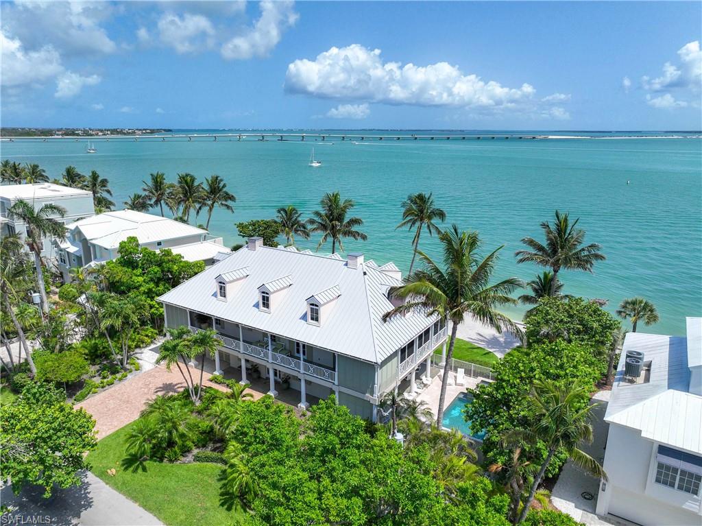 Stunning bayfront estate designed by renowned designer Bud Lawrence and built by Benchmark General Contracting, completed in 2009 with updates in 2017. This elevated 5BR/5.5BA home offers a total of 4,476 sq ft of luxurious living space and includes a separate parcel directly across the street on a deep water access canal with dock and water hookup—perfect for up to a 30-ft boat.
The gourmet chef’s kitchen features Crystal Cabinet Works custom cabinetry, granite counters, 8-burner LaCanche range with double ovens, brand-new 02/2026 paneled Sub-Zero refrigerator/freezer, Sub-Zero ice maker, JennAir wine cooler, and Miele dishwasher. A full laundry room is conveniently located on the main level. Elegant interiors include 10-ft ceilings, gas fireplace with travertine mantle, alabaster sconces, engineered dark wood floors, and slate tile floors on the lower level and lanais. The primary suite, located on the main level, offers breathtaking water views, two spacious walk-in closets, and dual offices.
Four guest rooms are located on the upper floor, each with its own en suite full bath. A full-size stackable washer and dryer is also located on this level for added convenience. Elevator services all three levels. The base level offers a spacious 2-car garage and bonus space with an exercise room that opens to a covered lanai adjacent to the beautiful outdoor pool and elevated spa.
Outdoor areas are designed for both relaxation and entertaining, featuring the beautiful pool and spa, expansive covered lanais, dog run, lush landscaping, and motorized fabric hurricane screen protective shutters on the main level lanai. The main level lanai also includes a fully equipped outdoor kitchen and a gas fireplace, perfect for alfresco dining and evening gatherings. A white sand beach on the bay provides a peaceful waterfront setting, ideal for children’s play or your own private relaxation area. Additional features include a new raised seawall and a whole-house gas generator with a new 800-gallon underground tank. All windows and doors are impact-rated.
Don’t miss this once-in-a-lifetime chance to own one of the most beautiful homes on Sanibel.