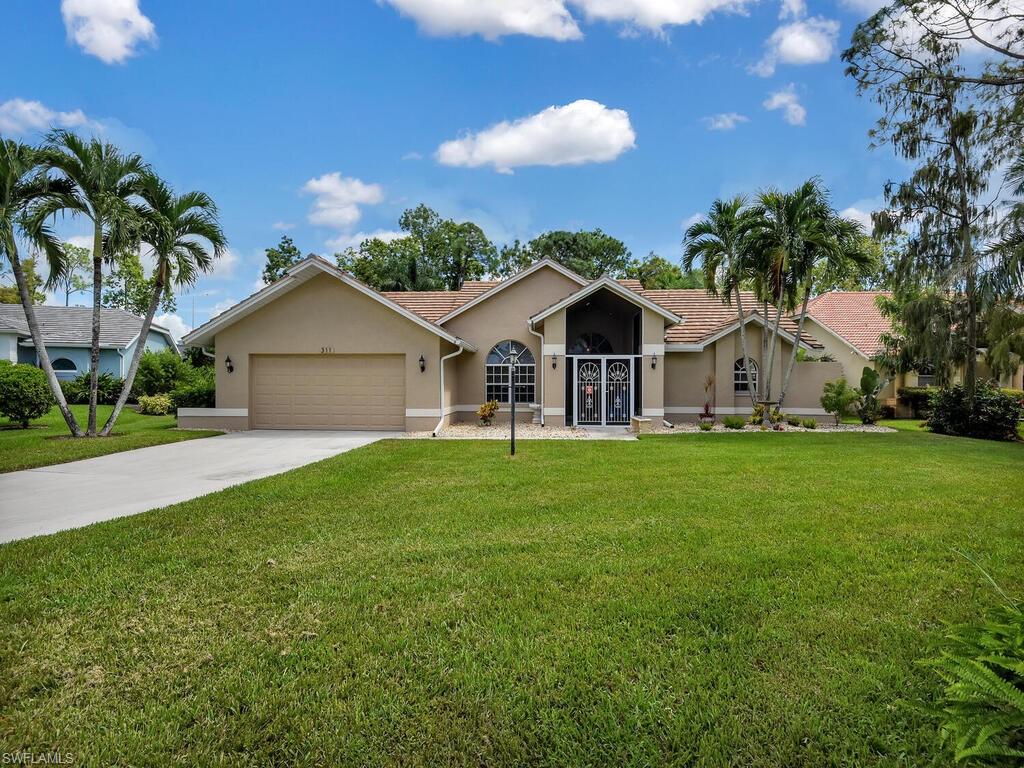 Houses like this don't come around often! Situated on over 1/2 acre lot on a cul-de-sac with extra long driveway, this 3 bedroom 2 bathroom home is loaded with upgrades.  These include porcelain tile throughout living areas, additional kitchen cabinets/wet bar area, granite counter tops, travertine backsplash, AC in garage, upgraded power supply to garage, new pool pump and resurfaced pool and deck area. Walking through the front door of this house you are met with a light and bright living space that flows into a large updated kitchen and family room. Living, family and master bedrooms open onto the extensive screened lanai area which has an island pre-plumbed ready for your outdoor kitchen. The fenced pool area is tranquil and private overlooking the large backyard and lush landscaping. Roof replaced in 2015. Berkshire Lakes has low HOA fees a community pool, tennis courts and bike jog paths. This house is located a 5 minute walk from groceries, restaurants and more.  Easy access to Olde Naples and I75.
