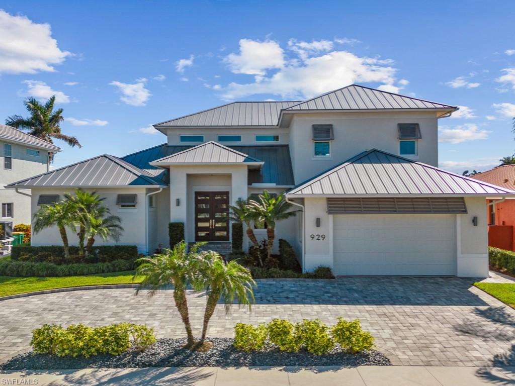ATTENTION GOLFERS! This home comes with the immediate transferable membership to the Marriott Members Club upon closing, once transfer fees and initiation fees are paid by purchaser. Enter this beautiful custom residence through estate doors and be captivated by the expansive converging waterway views. The open floor plan invites entertaining. Gourmet kitchen w/extra-large island and ample storage. Living room features an entire wall w/built in shelving, fireplace, recessed lighting, tv and sound bar, as well as a custom-built marble bar area. Impact glass throughout w/hurricane shutters for front door, upper and lower lanais as well as remote screens for the first floor lanai. The living room, dining room and front door have hidden rechargeable electric blinds. Master suite features two customized walk-in closets; master bath has central storage cabinet and gorgeous tiled wall w/niche. There is beautiful tile throughout the first floor. Upstairs there are three en-suite bedrooms, a family room with a beautiful entertainment center, wet bar, and a lanai showcasing absolutely stunning views. Pool w/spa (spa can be heated separately) all overlooking a large Trex dock with 24K lb lift and 5K lb kayak lift. Located on a quiet, hidden street (no through traffic) in a superbly convenient location, air-conditioned garage w/epoxy flooring, a circular drive, a newer seawall, and metal roof. Water access under the Smokehouse bridge that will accommodate large vessel. Membership at the club allows immediate access to two top-rated championship courses: The Rookery and Hammock Bay, with challenging layouts and park-like surroundings. After a day of golf, take a short trip to the members-only beach club at the JW Marriot and be pampered at the spa, with valet service, lounge chairs and umbrellas ready at your arrival.