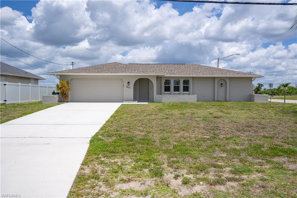 Welcome to 1601 NW 16th Terrace, a beautifully maintained 3-bedroom, 2-bath home situated on an oversized corner of Northwest Cape Coral. Offering over 1,400 square feet of comfortable living space, this home combines functionality, privacy, and value in one of the city's fastest-growing areas.  Step inside to discover a bright and inviting split-bedroom floor plan designed for everyday living. The spacious living and dining areas flow seamlessly together, creating the perfect setting for entertaining guests or enjoying quiet evenings at home. The kitchen offers ample cabinet and pantry space, making meal preparation both convenient and efficient.  The primary suite provides a private retreat complete with a walk-in closet and en-suite bath, while two additional bedrooms offer flexibility for family, guests, or a home office. Neutral finishes throughout create a move-in-ready environment that allows you to easily personalize the space to your style.  Outside, you'll appreciate the large lot with plenty of room to add a pool, outdoor living area, garden, storage building, or simply enjoy the extra space and privacy that is increasingly difficult to find. The screened lanai offers a comfortable place to relax year-round while enjoying Southwest Florida's beautiful weather.  Additional features include a 2-car garage, well and septic system, mature neighborhood setting, and convenient access to schools, shopping, dining, parks, boating, and all that Cape Coral has to offer.  Whether you're searching for a primary residence, seasonal getaway, or investment opportunity, this property delivers exceptional value, a desirable layout, and room to grow. Schedule your private showing today and discover why Northwest Cape Coral continues to be one of Southwest Florida's most sought-after destinations.