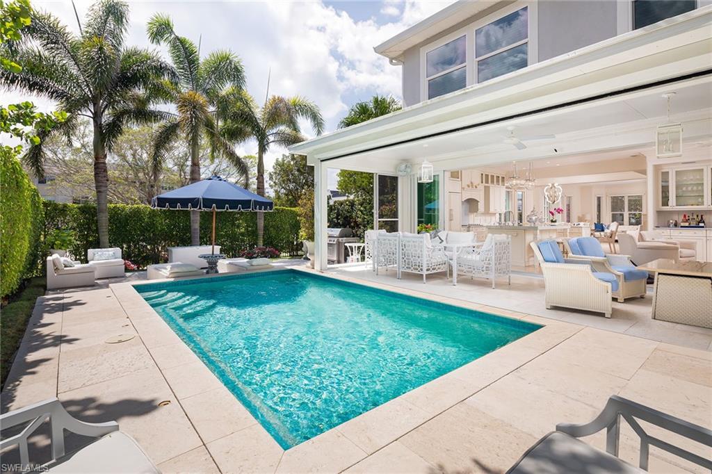 With no damage from recent Ian, this stunning, remastered villa is just steps from Third Street South and the beach and offers a spacious and sunny private pool and deck area, four bedrooms and expansive open floor plan. Situated with southern exposure and an end location, this home is flooded with natural sunlight. White bleached hardwood floors grace the entire living area with hard surface floors in the baths. The gourmet kitchen starts with a spacious island accented by Cleo Azure stone countertops and is appointed with luxury appliances. A disappearing wall of sliding glass doors opens the entire living area and kitchen to a 26-foot covered lanai with motorized screens, and further to the spacious pool area. Perfect for entertaining and the Naples lifestyle. The second level boasts a corner primary bedroom and private bath suite with high ceilings and loads of windows. Three more guest bedrooms, two more full baths and an efficient laundry tucked away complete the package. Offered furnished with a few exclusions. Just what you’ve been waiting for.