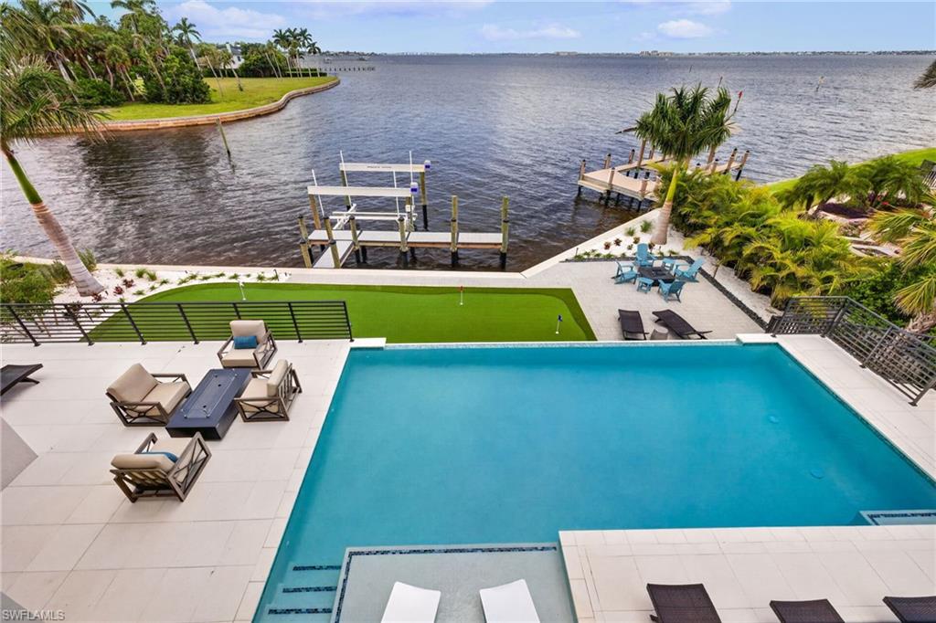 Welcome to The Whiskey Creek Model, Carlton-Naumann Homes’ newest luxury waterfront showcase located on prestigious Old Whiskey Creek Drive in the highly sought-after McGregor Boulevard corridor of South Fort Myers. This extraordinary Coastal Modern estate is perfectly positioned along the banks of the Caloosahatchee River, offering breathtaking water views and unforgettable sunsets from every room in the home.
Encompassing approximately 6,500 square feet of luxury living space (over 11,000 square feet total), this thoughtfully designed residence blends sophisticated architecture with effortless indoor-outdoor living. At the heart of the home is an expansive great room, designer kitchen, and dining epicenter created for both everyday living and exceptional entertaining. Culinary enthusiasts will appreciate the chef-inspired kitchen complete with a cleverly concealed back kitchen and walk-in pantry.
The residence features four private en-suite bedrooms, including a luxurious owner’s retreat with spa-inspired bath and direct access to a tranquil outdoor Zen shower and private deck. A separate cabana suite offers ideal accommodations for guests with added privacy. Designed for entertaining, the home includes a dramatic great room fireplace with entertainment bar, formal dining area highlighted by a temperature-controlled wine room and buffet, private office, and an impressive media/game room complete with billiards and bar alcove.
Outdoor living is equally spectacular, showcasing an expansive lanai with poolside kitchen, infinity-edge pool with in-water lounge seating, surrounding sun decks, fire pit, and beautifully curated gathering spaces. The backyard retreat also features a waterfront patio, private putting green, and flow-through dock system accommodating up to a 40-foot boat with direct Gulf access. Completing the estate is a four-car garage with custom C-Tech storage cabinetry and impeccable designer furnishings throughout and quality interior/exterior workmanship synonymous with Carlton-Naumann Home's 40-year reputation in developing exceptional custom homes in in S.W. Florida! 
Offered fully furnished, this exceptional waterfront estate also presents a unique 12 or 18 month leaseback opportunity for individuals whom wish to secure ownership now and postpone occupancy until their schedule prevails.  Many more unique and unexpected features to see in this incredible home so contact your Realtor soon for a private tour!!
.