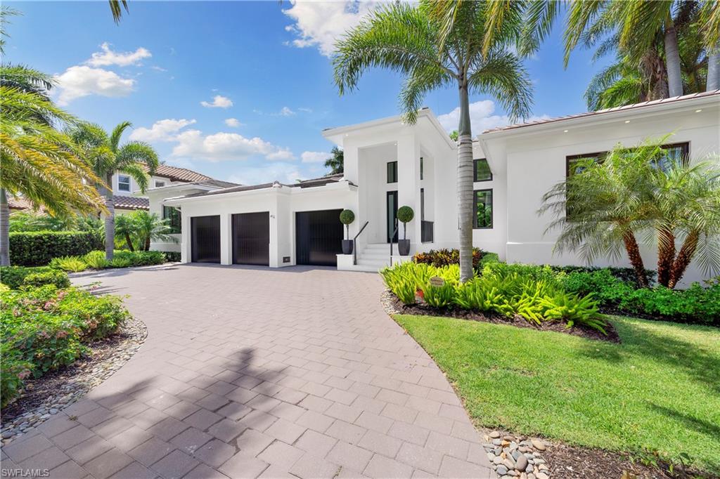Desired "West of Crayton" location, this newly built 4+Bed/5 Bath Moorings home has it all. Less than a mile to your private beach and on a quiet street enter to find an open floor plan with an abundance of natural light,  voluminous detailed ceilings & decorative beams. Fully pocketing impact sliders allow for seamless integration of the indoor/outdoor space. Ideal southern exposure provides sun all day on your outdoor oasis complete with pool + spa, built in grill and lounge w/ fireplace and T.V. The expansive great room floor plan features wide plank oak flooring & opens to dining room with custom bar and kitchen complete with island seating, ample counter space, and Thermador appliances. Primary suite features dual walk-in closets, a spa like bathroom with a shower & soaking tub, dual sinks, makeup vanity and skylights for even more natural light. Three additional guest rooms (all ensuite) w/ a den/office that can easily handle overflow guests. This fully-fenced property is landscaped with privacy in mind & complete with circular, paver driveway and 3-car garage. Added bonus of  "turnkey" furnished + significant rental income for those not ready for full time life in Naples!