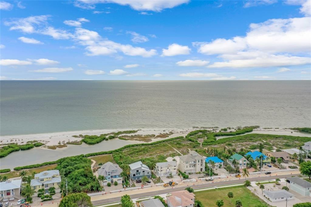 Charming “Old Florida Style” large, beachfront home on the south end of the island offering 180 degree views of the Gulf of Mexico. The desirable open concept living gives a warm, welcoming feeling which is great for entertaining. The large great room with soaring ceilings includes the living room, den, dining area and kitchen. The living room, kitchen and 3 of the 4 oversized bedrooms have sliding glass doors that take you out to the open aired decks for soaking in the sun and enjoying the gulf breeze. There is a master suite on each level and the 2nd floor suite has a small kitchenette and its own outside entrance. A wood spiral staircase leads you to 3 of the 4 bedrooms and a cozy loft that overlooks the living room and stunning views of the Gulf. Two Central A/C systems provide zoned heating and cooling and two oversized garages with a workshop/storage area. A private path takes down to the beautiful white, sandy beach that overlooks crystal turquoise waters. Close to shopping, dining, public marinas, boating, fishing, Bonita Springs and Downtown Fort Myers Beach. The property is being sold turnkey and fully furnished. Agents see confidential comments regarding lot size.