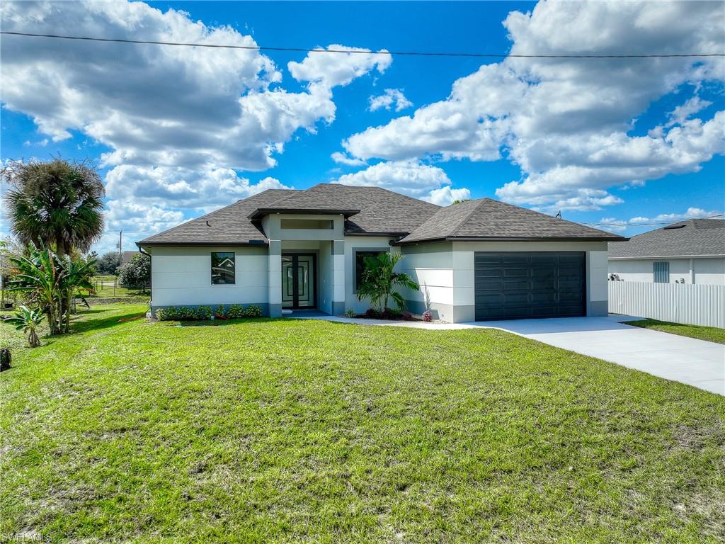 Welcome to this beautifully ready to move in 3-bedroom, 2-bathroom home with a spacious den, located in the Lehigh Acres neighborhood. This brand-new construction boasts a perfect blend of modern design and functional features, ideal for comfortable living. As you enter, you’re greeted by high tray ceilings and the sleek LVP flooring that flows throughout the open-concept layout, highlighting the home’s spaciousness and bright, airy feel. The heart of the home features a gourmet kitchen with gorgeous quartz countertops and backsplash, and a large island perfect for cooking and entertaining. High-end stainless steel appliances complete the space, making it a dream kitchen. The living area is flooded with natural light through impact doors and windows, offering both beauty and peace of mind. Elegant light fixtures and charming barn doors add a touch of sophistication to every room. The master suite is a true retreat with an en-suite bath featuring walk-in shower with glass doors, and plenty of closet space. The additional bedrooms are well-sized and share a beautifully designed second bathroom. Enjoy the convenience of a two-car garage and modern finishes throughout, making this home the perfect choice for the new owner. NO HOA and NO FLOOD INSURANCE. Don’t miss the opportunity to make this home your own! Schedule a tour today to experience all that this stunning new construction has to offer.