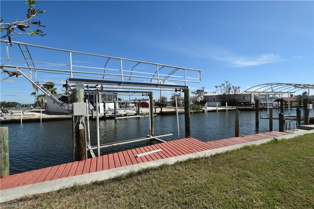 LOWEST PRICED PIECE OF PARADISE OFF MAIN STREET where you OWN your own land AND have a water view and A boat dock!!!  Margaritaville and the bustling Times Square area just a 10 block walk or bike ride. This large lot has a private boat dock with a 10,000 lb. lift. Just minutes to the back bay to catch that yummy meal. Still have time for fun after a beach or boat day? Head to Parrot Key, Doc Fords, Dixie Fish House, Bonita Fish House.  Just 5 blocks either way.   Key West Express is just down the street.  Take a day trip without the worries of driving over there in heavy season and parking.  This over 55 community is a beautiful street with the friendliest people around. Build your dream home or your paradise vacation on YOUR OWN LOT. Come and live the beautiful Florida lifestyle!   Upgraded city water/sewer system coming in future.