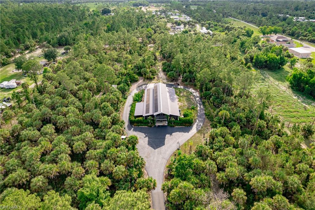 Rare opportunity to own 15 private acres in Golden Gate Estates featuring a custom-built 2022 all-steel barndominium, three separate 5-acre parcels, and a whole-property solar and battery backup system. This unique estate offers approximately 4,200 square feet under air, 5 bedrooms, 4 bathrooms, an 800-foot paved driveway, and more than 100 irrigated fruit trees.

Designed for both everyday living and entertaining, the home features exposed steel beams, concrete floors, a spacious chef's kitchen with commercial-grade appliances, oversized island, double farm sinks, two dishwashers, and extensive storage. The approximately 1,500-square-foot enclosed garage with a 14-foot-high door provides ample space for RVs, boats, equipment, workshops, and car collections.

The property is served by private well water and a substantial solar energy and battery storage system, allowing the home to operate either connected to the grid or independently when desired. Rural Fringe Mixed Use zoning provides flexibility for residential and agricultural uses, including equestrian, homestead, hobby farm, family compound, or private estate opportunities.

Sale includes the adjacent 5-acre parcel to the west (PID 00303240004) and the adjacent 5-acre parcel to the east (PID 00303160003), for a total of approximately 15 acres across three separate parcels.