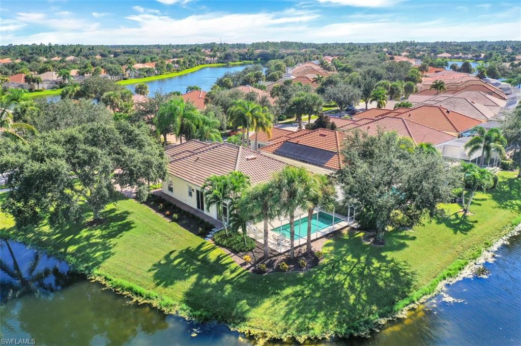Opportunity Knocks...This is your chance to have ALL THE UPGRADES that Matter! BRAND NEW ROOF & GUTTERS (2022), HEATED POOL with preferred South Exposure and an OVERSIZED LOT surrounded by water on the South & West, providing the feeling of living on your own Private Island with mesmerizing WIDE LAKE & BRIDGE VIEWS. As darkness falls the Lighting makes views of your freshly Landscaped Gardens feel truly magical. Owners chose this home for its PRIVATE location close to the Entry Gate & a short stroll to Town Center. This 3 Bedroom 2.5 Bath home has the popular Side Entry 2 Car Garage, a Widened Driveway & the Screened Entry welcomes cooler Naples breezes saving A/C $$. The Open Plan has 12 foot Ceilings, Entertainment Center & Pull-Outs for easy access in the sunny Kitchen. Enjoy Upgraded A/C, Crown Molding, Plantation Shutters, Electric Awning, Extra Storage Cabinets in Laundry Room & Garage, Central Vacuum, Security System & Electric & Lexan Storm Shutters for your peace of mind. IslandWalk has Amenities Galore & LOW FEES include HDTV, High Speed Internet, Irrigation & Lawn/Landscape Care. Close to white sand Beaches, Dining & Shopping. Welcome to your Private Haven in Paradise!