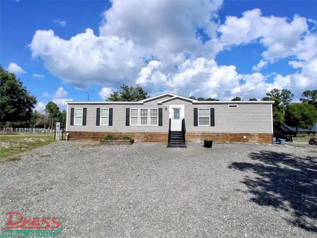 Welcome home to this New Construction 2023 Live Oak Homes Model #D-3604B Tunda 1,740 sq ft 4-bedroom 2-bathroom DW Home located on 3.75 acres of non-wetland and not in flood zone land. This Manufactured home is customized with a multi-use mud room and washroom with sink with an exit, for a total 3 exit doors . Wind zone 3, Deluxe Drywall, 32'x 64'. Kitchen has custom wood interior designed plank wall and pantry door, a modern farmhouse feel. A deep Stainless-steel sink and appliances. Large kitchen island. Sliding glass doors to the backyard. Both bathrooms have double vanities. Large master bedroom with huge walk-in closet. The master bathroom boasts a large, tiled shower with black matte grid glass and pull-door, separate tub and separate toilet room. Rooms are carpeted except bathrooms, kitchen and mudroom lined with linoleum. Property is fenced in with extra wide culvert and two tarter gates. Two sheds staying on property for storage, one including the well and water softener. Plenty of room for your horses and animals. This property is located in the rural community of Montura Ranch Estates, horse and golf-cart friendly with NO HOA's. Pay no city taxes. One of your larger properties for sale now. 1.5 hr from each coast. This rural community is growing. Have access to the poolhouse and clubhouse at no extra cost. Convenience stores located within community while being 25 min from the city of Clewiston. Call to schedule your private showing today!