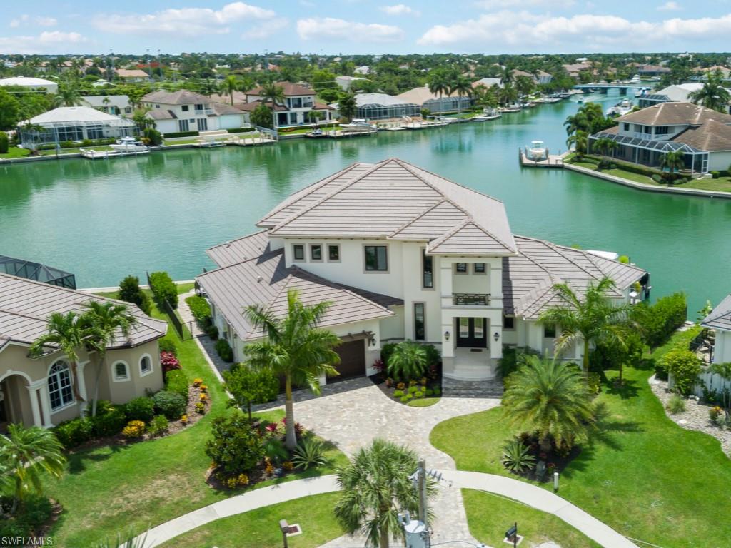 Why wait years for a new home to be built when you could move right into this nearly brand new luxurious residence with a new 168' seawall.  Southern exposure tip lot with quick access to Caxambas Pass; sites like this are almost impossible to find!  Extensive dock with lifts, complete with a sundeck!  Enjoy swimming in the saltwater pool, lounging in the spa, or relaxing by the gas fireplace.  
Take in breathtaking water views as you walk through the front door.   This home is perfect for entertaining with five en-suite bedrooms!  For a total of 5 and 1/2 baths!  Two of the five are master suites, and the first level suite features a private lanai.
The upstairs game room is a perfect place for guests to lounge with access to a large balcony shared with two of the three upstairs bedroom suites.  The view is fantastic!
The open concept kitchen is a chef's dream!  You are cooking with gas here!  Don't miss the secret butler's pantry with loads of extra storage.  
Amenities not to be missed include a whole house generator with a 500-gallon propane tank, a three-car garage with a textured epoxy floor, a stand-alone ice maker, and more!