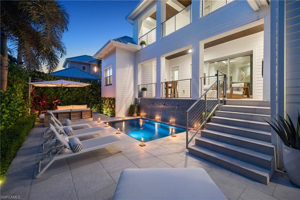 Ideally situated in the heart of downtown Naples, this completely remastered single-family residence embodies the essence of refined Florida living. Thoughtfully designed with elevated finishes throughout, the home welcomes you through a dramatic two-story foyer highlighted by soaring ceilings, architectural millwork, and a striking staircase that sets the tone for the interiors beyond. The flowing floor plan is both spacious and inviting, centered around a beautifully appointed kitchen featuring an oversized island and seamless connection to the dining and living areas — ideal for both everyday living and effortless entertaining. Pocketing impact glass doors open to the covered lanai with a summer kitchen, extending the living space outdoors to a generous lawn perfectly suited for gatherings, pets, and family enjoyment. The first-floor primary suite offers a private retreat, accompanied by a dedicated office, while guests are comfortably accommodated with their own upstairs living area and three ensuite bedrooms. Just moments from the charm of Olde Naples, residents can spend evenings strolling to renowned dining, shopping, and the nearby beaches, enjoying the convenience of downtown living right outside their door.