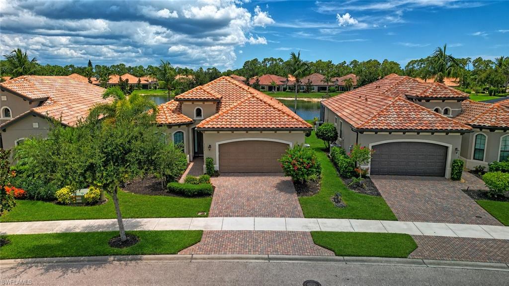 The peaceful lake and fountain views are what you'll remember most about this turnkey home in Bonita Isles. From the outdoor kitchen to the extended screened lanai overlooking the water, this home was designed to make the most of Florida living. The extended screened lanai is where you'll likely spend much of your time, whether you're enjoying your morning coffee, watching herons and egrets along the shoreline, gathering with family and friends, or simply unwinding as the fountain provides a peaceful backdrop. Accordion storm shutters fully enclose the lanai, while impact-resistant windows and doors throughout offer added peace of mind. Inside, high ceilings and a two-step tray ceiling in the great room create a bright, open feel. The living, dining, and kitchen areas flow effortlessly together, making it easy to entertain or simply enjoy everyday life. The kitchen features abundant cabinetry, a large center island, under-cabinet lighting, and generous counter space for everything from casual meals to holiday gatherings. The den offers the flexibility to fit your lifestyle, whether you need a home office, TV room, hobby space, or an additional bedroom for visiting family and friends. The spacious primary suite overlooks the lake and features dual walk-in closets, split vanities, and a private bath designed for comfort. The guest bedroom includes its own ensuite bath, providing privacy for family and visitors alike. Throughout the home, you'll find tile flooring with luxury vinyl plank in the bedrooms, there's no carpeting anywhere! Bonita Isles is a gated community with sidewalks on both sides of the street, making it easy to enjoy a morning walk or take a short stroll to the clubhouse. Residents enjoy a resort-style pool, fitness center, tennis courts, pickleball, and a vibrant social atmosphere. Low HOA fees include lawn care, and with no CDD, you'll enjoy lower carrying costs while spending more time enjoying everything Southwest Florida has to offer. Conveniently located just 6 miles from Bonita Beach, this home is also minutes from downtown Bonita Springs, downtown Naples, Coconut Point Mall, Miromar Outlets, Mercato, Southwest Florida International Airport (RSW), championship golf courses, restaurants, and entertainment. Whether you're searching for a full-time residence or a seasonal retreat, this home offers an exceptional combination of location, comfort, and the Southwest Florida lifestyle.