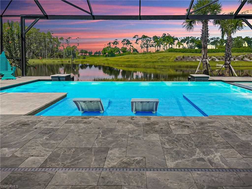 INFINITY EDGE CUSTOM POOL ~ WHOLE HOUSE GENERATOR ~ AIR COND & OVERSIZED 3 CAR GARAGE ~ EXTENDED LANAI w/ TRAVERTINE PAVERS ~ OUTDOOR KITCHEN ~ STORM SMART REMOTE SHUTTERS ~ KINETICO WATER FILTRATION SYSTEM are just a few of the upgrades in this NEARLY NEW Stonewater Loft Pulte home. Priced to SELL, this South Western-facing home boasts 4 bedrooms plus a den, 4 baths, an oversize loft with a beverage serving area, and beautiful evening sunsets.  This home has plenty of space for entertaining, with a huge kitchen island, an open family/dining/kitchen area, upgraded appliances, a large walk-in pantry, an outdoor kitchen with 42" gas grill, double beverage coolers & wood fire pizza oven. Wildblue is a NATURAL GAS community with true resort-style amenities, and an active boating, tennis, and pickleball community. Phase 2 of amenities to be completed 2nd quarter of 2023 with indoor/outdoor dining & resort-style pool and lakefront beach! Why buy new when you can get this nearly new home with so many after-market upgrades while also SAVING AT LEAST $15,000 in one-time new construction closing costs? Close to shopping, dining, beaches, and RSW International Airport. MOTIVATED SELLERS!