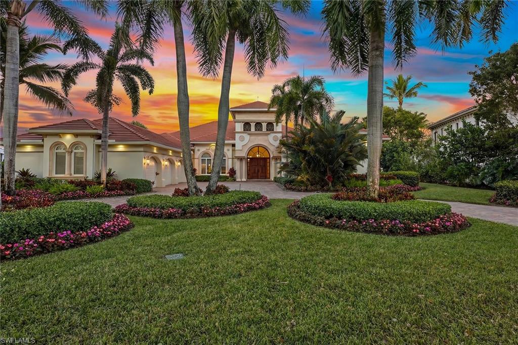 Gracefully positioned on an expansive .73-acre homesite within Isla del Sol, Fiddler’s Creek’s prestigious and private enclave, this exceptional custom-built estate overlooks the renowned Rookery Golf Course with tranquil lake and sweeping fairway vistas, while eastern rear exposure welcomes radiant sunrise skies across the outdoor living spaces. A sweeping circular drive enhances the grand arrival, complemented by lush tropical landscaping, a 2024 tile roof, and stately mahogany entry doors crowned by an arched transom and sidelights. Offering approximately 6,700 square feet of living area, this meticulously maintained residence features four bedrooms plus a private study, six-and-a-half baths, and a three-car garage, blending timeless craftsmanship with impressive scale. Inside, soaring ceilings, including a dramatic 13-foot living room, 10-foot sliding glass doors and 8-foot interior doors create a gallery-like ambiance, while natural stone flooring laid on the diagonal with custom inlays, tray ceilings, crown molding and in-ceiling speakers elevate the refined atmosphere. Walls of mitered glass frame breathtaking pool, lake and golf course views from living and family rooms, the latter anchored by a gas fireplace and a granite-topped bar with Sub-Zero wine refrigeration, U-Line beverage refrigerator, ice maker and custom cabinetry. Designed for culinary excellence, the chef’s kitchen showcases Sub-Zero refrigeration, a Wolf six-burner gas cooktop, Dacor wall oven and warming drawer, Miele dishwasher, granite countertops, tumbled marble backsplash, custom appliance garages, a center island, walk-in pantry and extensive task lighting. A double-door study with engineered hardwood flooring and a built-in granite desk adjoins a billiards area and full bath, offering flexibility for work or leisure. The primary suite is a private sanctuary featuring a fireplace, tray ceiling, wet bar with Sub-Zero under-counter refrigerator, dual custom walk-in closets, and a dedicated exercise or massage room opening to a secluded garden patio, while dual spa-inspired baths offer natural stone finishes, marble vanities, a jetted soaking tub, bidet, and frameless glass showers with dual shower heads. Guest accommodations include two en-suite bedrooms in the main residence and a private guest cabana with full kitchen, living area and bath, ideal for extended stays or multigenerational living. Outdoor living is extraordinary, highlighted by a gas-heated infinity-edge pool and spa, summer kitchen with DCS grill and gas cooktop, tongue-and-groove ceiling, outdoor fireplace, and covered lanai overlooking the lake and Rookery fairways. Additional features include electric roll-down shutters, security system, central vacuum, tankless water heater, new HVAC system (2024) with UV light purification, an oversized laundry room and an epoxy-finished three-car garage, completing this impeccably maintained estate.