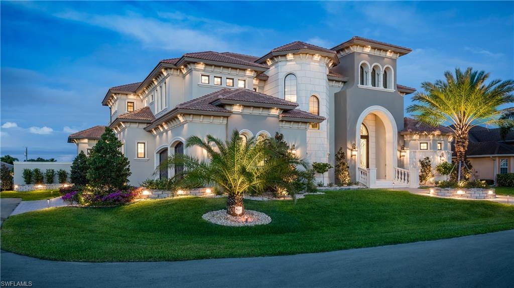 This one-of-a-kind new custom home blends a modern waterfront elegance with old world class. Outdoor entertainment is brought to life with a stone-faced fireplace topped by an oversized flat-screen TV, fire bowls and fire pit which illuminate the pool, pool deck and spa and a full outdoor kitchen which all overlook one of the largest canals in Cape Coral (around 150’ across and 28’+ deep). The outdoor living space flows seamlessly into the open grand room, creating an amazing area to take full advantage of the Southwest Florida lifestyle. Inside, marble and hardwood floors extend out before you while custom wrought iron and coffered ceilings amaze above. Custom cabinetry and dual oversized islands adorn the kitchen along with Sub Zero and Bosch appliances and countertops of quartz, granite, and marble. The walk-in pantry boasts a wet sink and dishwasher. The expansive master suite is on the first level. Your guests will enjoy the entire second floor complete with a spacious loft with custom built ins framing a 98" television, a private outdoor living space and wet bar area. All of this comes to life with the push of one button using the fully integrated home automation system.