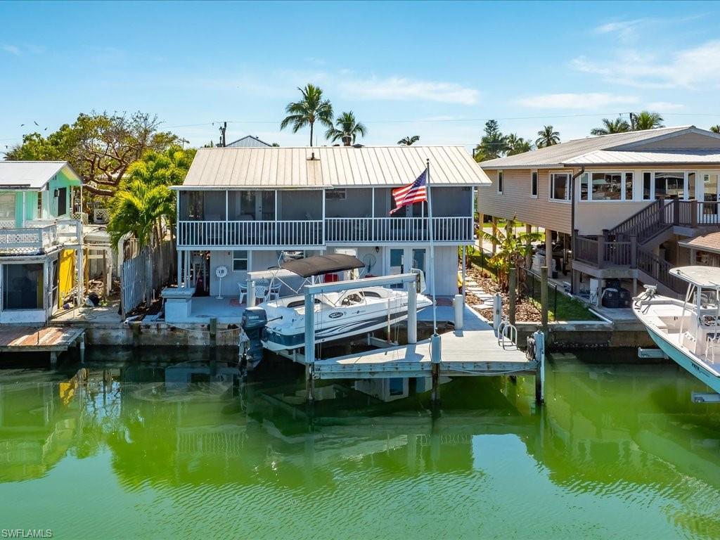 Don’t miss this opportunity PRICE REDUCED!! Calling ALL FISHERMEN AND AVID BOATERS!!! This home offers INCREDIBLE DIRECT GULF ACCESS ~ Enjoy this BREATHTAKING LARGE OPEN BAY VIEW and everything that coastal island living has to offer! The upstairs features an updated kitchen with stainless steel appliances, under cabinet lighting and granite counter tops, 3 bedrooms 3 bathrooms, 2 screened balcony, a dining area and that’s only upstairs. Downstairs boasts a BAR, POOL-TABLE, two additional bedrooms, a full bathroom, NEW washer and dryer, an extra refrigerator, storage area, covered parking and even a garage. The private dock and boat lift make living the Florida lifestyle effortless with the convenience of a short idle to the world class fishing of the 10,000 islands and all located in the historic fishing village of Goodland. A golf cart ride away from the popular Stan's Idle Hour, Little Bar, Paradise found & Crabby Lady restaurants, a county boat launch, 2 private marina’s, Kirk’s fish market, post office, museum, playground and park. Goodland has a voluntary civic association and is a golf cart community! NO HOA OR CDD FEES!!! Call today to schedule a private showing!