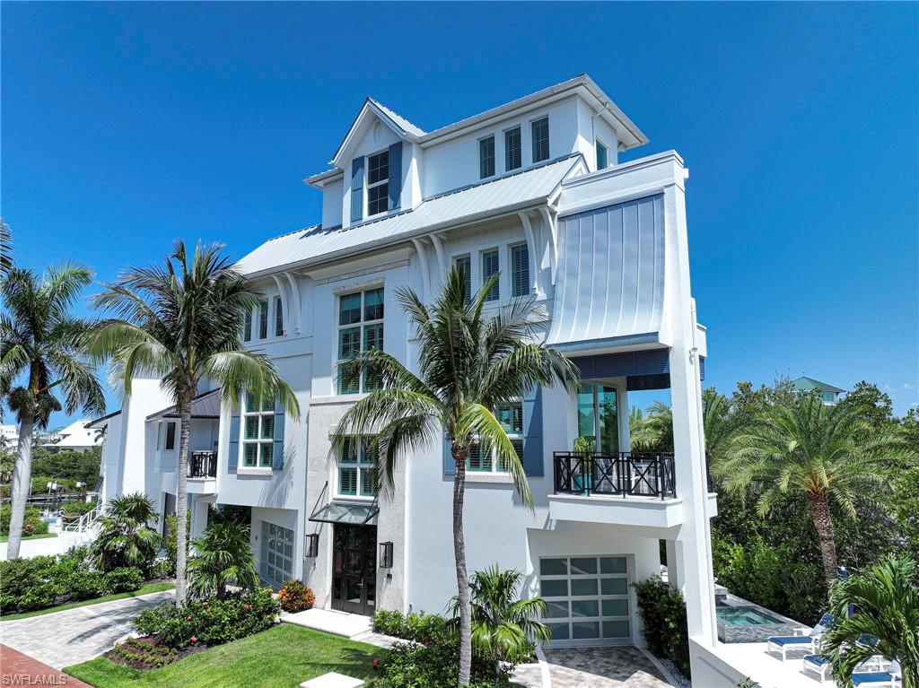 This 4 story coastal contemporary bayfront home offers the ultimate in Florida luxury waterfront living including: best location in the double gated community of Bayfront Gardens and within Beautiful Barefoot Beach, the home sits on 131 feet of waterfront and provides premier boating from your private 80’ Boat Dock with a 20,000 LB lift and quick access to the Gulf of Mexico with no bridges. It also has private beach access to the white sandy beaches of Barefoot Beach right across the street from the Bayfront Gardens entrance. Home was completed in 2018 and shows as new with the highest level of finishes, fixtures and workmanship throughout its over 8200 Sq Ft of living/entertaining space and nearly 4500 Sq Ft under air that includes an open floor plan with water views from every level and yet offers one of the most private settings you will find in all of Barefoot Beach. The first floor covered lanai has been finished to the same outstanding quality and selection of finishes of the rest of the home including a large summer kitchen with gas grill, refrigerator, full pool bath, plus an eating area all overlooking the private 95 ft pool deck with 7 ft waterfall, spa & flowing fire pots that offers a spectacular day and night setting. Features include volume & vaulted ceilings, wall & ceiling details with endless millwork including beams, square edge tongue & groove on every level, Wide plank European oak wood floors, upscale cabinetry throughout the home including a gourmet kitchen that was designed by Allikriste Cabinetry, the highest levels of countertops available, appliances including 48" Wolf Range, all Sub Zero refrigeration, Miele coffee maker, 2-ovens, warmer, steamer, microwave, full size wine cooler, morning bars, one touch lighting, private elevator to all 4 floors and garage space for 3 cars. The main level is full of natural light including the great room which offers custom cabinetry, large screen tv and audio video components, den/office is conveniently located off the great room, a large deck with water views is just off the dining room and the kitchen is open to all the areas. There are 4 Bedrooms, 5 1/2 baths, that include a master suite, 2 guest bedrooms with en suite luxury baths, plus a 4th floor suite with bedroom, full bath, living room, morning bar and deck with forever water views or you can use it as a cloud room for second entertaining area. The outside of the home offers one of the most appealing designs and street appeal in the community and includes white stucco, shutters, standing seam metal roof, oversized corbels, impact glass garage doors tropical landscaping and lighting package for the ultimate evening entertaining. Barefoot Beach is one of Collier County’s finest gated beach communities and provides 24 hour guard patrols, one of the highest ranked beaches in the country and simply an amazing place to live.