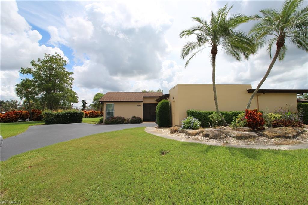 Your private Villa in the heart of Naples, close to 5th Ave and the beaches. Lives like a single family home with private entrance, long driveway and extra parking. Over-sized one car attached garage and large utility/storage room. Exceptional golf course view, very private and right next door to the Lakewood Club House, restaurant, pool & tennis available for a low entry fee. LOW HOA fees, this is a Homeowners/single family property hard to find in Naples in this great condition and location. 2 bedrooms/2 bath and huge living/dining area, corian counter-tops in kitchen, new impact windows throughout . Enclosed lanai offers sunny Florida room/den. Get your piece of paradise!