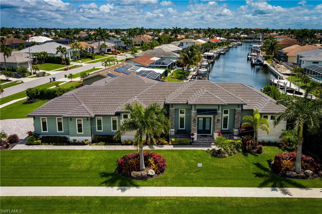Discover the pinnacle of coastal luxury in this 2024-built masterpiece on Marco Island. Situated on an oversized corner lot of over 16,000 sq ft, this single-story estate offers sweeping long-water canal views from nearly every room. The light-filled interior boasts premium Travertine flooring, custom wood ceiling details, and a gourmet kitchen equipped with Sub-Zero and Wolf appliances, a walk-in pantry, and a large island. Floor-to-ceiling zero-corner glass sliders seamlessly open to a screened lanai featuring a custom heated pool and spa. Outdoor entertaining is effortless with a plumbing-ready setup and a $15,000 outdoor kitchen enhancement package provided by the owner. For boating enthusiasts, the private dock features a 30-foot slip and a double jet ski lift with direct gulf access under the new Barfield Drive bridge. Premium upgrades include a whole-home Generac generator, impact windows/doors, and an epoxy-finished 3-car garage. A true waterfront sanctuary.