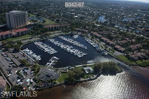 Major price reduction($70,000)  for this lovely top floor vaulted ceiling 2 plus den condo in a very desirable community and location.  Across the street from the marina that offers you an amazing golf and lake views and  rolling greens and waterfront vistas with amazing sunrises from lanai.  Owner recently put in new kitchen cabinets, tumbled marble backsplash, granite counters, LED lighting, tray ceiling, newer kitchen appliances including washer and dryer. Bamboo flooring, upgraded baseboards, plantation shutters. Master bath offers new sinks, fixtures, doors.  Den area is ideal with built ins. Condo is being offered turnkey and move in ready. Storm shutters a great bonus. The rooftop areas are great for entertaining and grilling. Carports offer additional storage.  Close to the community pool and loads of benefits at this amazing location. You will love this active lifestyle community - bocce, pickle ball, 13 har- tru tennis courts, 18 executive golf course, 192 wet slip marina as well as dry storage, kayaking, fitness center, lap pool as well as community pools, walking and biking trails throughout the development.  Located off McGregor Blvd. close to downtown, clubs, theater, comedy clubs, shopping and area restaurants.