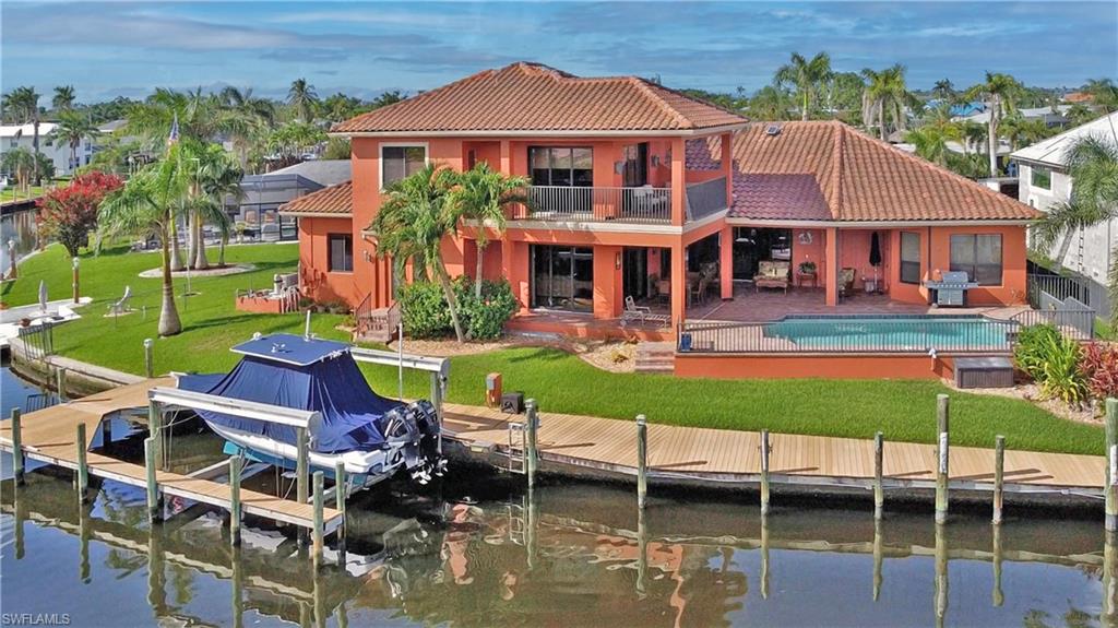 Boater and car enthusiast dream home!! 2010 built Arthur Rutenberg Direct sail-boat GULF ACCESS pool home with sweeping views of Bimini Basin in desirable Cape Coral's 'Yacht Club' neighborhood. This award-winning St Tropez III floor plan is customized to take full advantage of the gorgeous water views, which extend out 900+ feet across the Bimini Basin. This spacious 3738 square foot home features 3 bedrooms, 3.5 bathrooms, 1321 sq ft with two car lifts EIGHT (8)CAR GARAGE, formal dining room, office, second floor den/exercise/family room with wet bar, second floor wrap-around balcony. The master suite is on first floor. Gas stove top. Three AC units. Beautiful appointments through-out including crown molding, high coffered ceilings and doorways. Solar heated inground pool. Solid construction: second story is also concrete block, tile roof, and IMPACT WINDOWS and doors, home has never had any water intrusion, even from Ian. The house sits on the corner of the Basin and Tarpon Canal with 154 feet of waterfront on almost a 1/3 acre. Large composite boat dock with a Captain's walk and a 27,000 lb BOAT LIFT. By boat, the river is a straight ride down the Bimini Canal, no bridges. Cape Coral is transforming its downtown area, and this home will be in the heart of it. Only minutes away from the City's upcoming new 200 million dollar Yacht Club and the new restaurants and retail downtown. The Basin always has boat activity to watch, and provides a front row seat to the City's annual Holiday Boat along. On a dead end street, you'll see more boat's in the back yard than cars passing in the front. Short distance to the Yacht Club, restaurants, retail, and the exciting redevelopment of downtown Cape Coral.  Floor plan available.