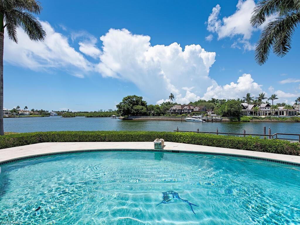 H7191 - Take refuge in exclusivity.  Poised at the end of a quiet cul-de-sac, 525 Admiralty Parade West sits on 0.6 acres with 189' of water frontage overlooking Man-O-War cove to the east and Doubloon Bay to the west.  The lovingly maintained residence currently nestled on the parcel is generously sized at over 5,000 sq. ft. under air and would be an ideal candidate for renovation or rebuilding as it offers an unparallel backdrop of glistening waters and manicured lawns.  At the edge of the property, a private boat dock offers residents with watercraft just a few minutes' worth of direct cruising to Gordon Pass, as well as allows quiet evening cruises through the many canals found within the exclusive community.  This residence also qualifies for Primary Resident Membership at the prestigious Port Royal Club.