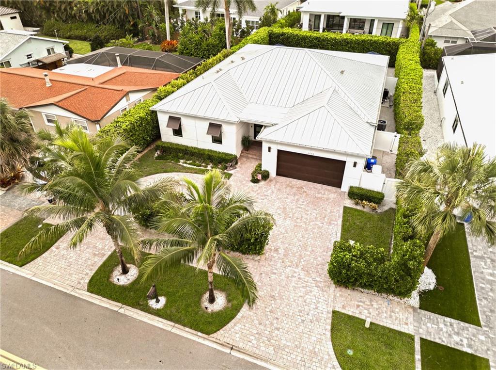 Exceptional craftsmanship, timeless design, and uncompromising quality define this one-of-a-kind custom residence. From the moment you step inside, the striking contemporary architecture, dramatic covered entry, and custom double doors set the tone for a home where every detail has been thoughtfully curated. Built to an exceptional standard, this residence showcases a level of quality and attention to detail rarely found in today's market. Inside, soaring ceilings and stunning stained tongue-and-groove wood ceilings with architectural recessed LED lighting create a warm yet sophisticated atmosphere throughout the main living areas, primary suite, and covered lanai. Expansive casement windows, solid-core doors, custom millwork, and large-format porcelain tile flooring reflect craftsmanship more commonly found in Naples' premier luxury homes. Designed for effortless entertaining, the open floor plan blends indoor and outdoor living through expansive sliding glass doors spanning the rear of the home. The chef's kitchen features sleek custom cabinetry, quartz countertops, an oversized island, premium appliances, gas cooktop, built-in wine refrigerator, designer tile backsplash, and abundant workspace. The resort-inspired lanai features matching tongue-and-groove wood ceilings, an outdoor kitchen, propane firepit table, multiple seating areas, and overlooks the sparkling saltwater pool and spa. At night, professionally designed architectural and landscape lighting transform the property into a breathtaking private retreat. The luxurious primary suite offers direct lanai access, matching tongue-and-groove wood ceiling, and a spa-inspired bath with a freestanding soaking tub, oversized walk-in shower, dual vanities, and designer finishes. The split-bedroom floor plan provides exceptional privacy, while the third bedroom features a Murphy bed, allowing it to function beautifully as a guest suite or executive home office. Luxury extends well beyond what you can see. Control4 whole-home automation, Lutron motorized shades, impact-resistant windows and doors, whole-house generator, and a buried 500-gallon propane tank, also serving the gas cooktop in the kitchen, provide exceptional comfort, convenience, and peace of mind. Towering Calusa hedges surround the fully fenced backyard, creating an extraordinary level of privacy. With more than $350,000 in thoughtfully selected upgrades beyond comparable homes, this residence delivers a level of quality and craftsmanship that can only be fully appreciated in person. Ideally located just minutes from Naples' white-sand beaches, downtown, 5th Avenue South, exceptional dining, shopping, and entertainment. A comprehensive Features & Upgrades List is available for review during showings.