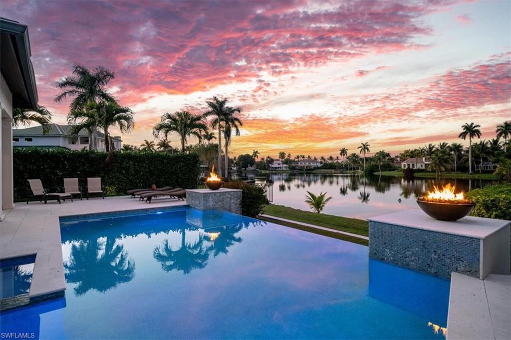 Welcome to 410 Palm Circle West, a meticulous lakefront estate designed by Stofft Cooney Architects and built by SGM Building Group. Desirably located in Old Naples, near the new much-anticipated Four Seasons Resort, and only three blocks from the beach. This sophisticated residence is redefining Naples luxury living. The finest materials and finishes have been chosen including superb hardwood white oak floors throughout. The first floor consists of a foyer with 26-foot-high shiplap ceilings, two opulent suites, a study, a fitness room, a gourmet kitchen equipped with Sub-Zero and Viking appliances, wine fridge and two separate man-made quartz islands and a stunning great room with high ceilings and a gas fireplace. Adjacent to the crystal waters of the infinity pool is a covered outdoor living space featuring a gas fire ribbon, additional cooking area and ample space to lounge and dine perfect for entertaining guests. The second floor contains a lounge and two additional plush bedrooms overlooking the lake with ensuite bathrooms. The three-car garage provides ceilings high enough for lifts. Don't miss this exceptional opportunity to call Naples home in this sublime residence.