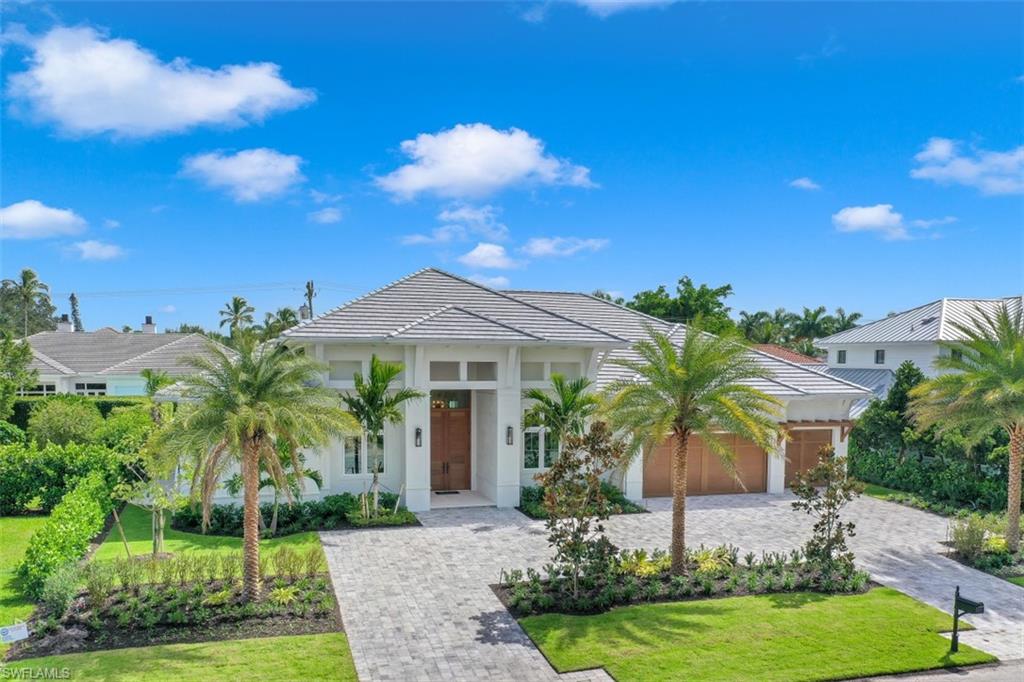 FURNISHED new custom home in the Moorings close to beaches and golf, is luxury at its finest. Thoughtfully designed by Sally Richardson Interiors, high-end finishes are everywhere. Legno Bastogne French white oak flooring, Sub-Zero and Wolf appliances, custom cabinetry with quartzite & marble countertops, designer tile, and beautiful trim and ceiling woodwork throughout. Mahogany double doors welcome you into the light and airy foyer with a custom English artisan ceiling.  Great room includes custom built-ins with electric fireplace, and a full wet bar with separate Sub Zero Wine storage. The open kitchen design with oversized island, and walk-in butler’s pantry are an entertainers dream. Fully retractable sliders connect the indoor space with a gorgeous lanai, featuring a summer kitchen, gas fireplace, retractable screens, and a pool & spa with lush landscaping that take advantage of the Southern exposure.  Retreat to the gracious master suite with his & her custom closets and spa like master bath.  Three additional bedrooms feature on-suite baths and custom closets. Lutron home automation system with home security and cameras paired to a central touchscreen, on your phone.