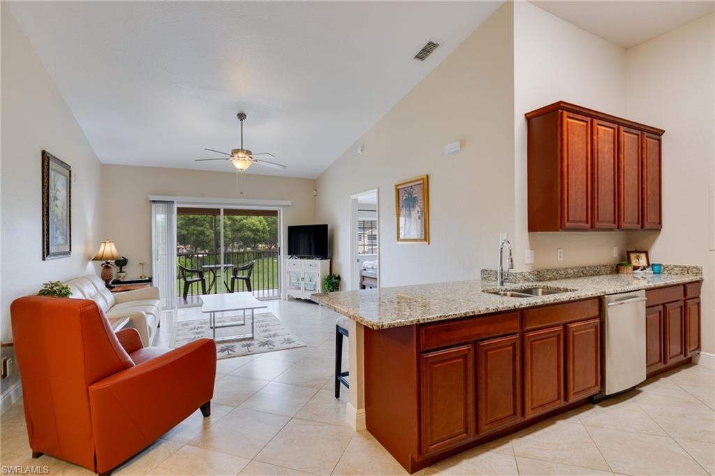 This second-floor condo is bright, open, and easy to maintain. Because it is on the top floor, you get vaulted ceilings that make the entire living area feel much larger and more spacious.

The kitchen features granite countertops, warm wood cabinetry, a stainless steel refrigerator, and a breakfast bar. There is also a dedicated dining space right off the kitchen. The main living areas have tile flooring throughout, leading out to a screened-in lanai. The lanai overlooks a quiet, wide-open green lawn, making it a perfect spot to relax.

The bedrooms and the bathrooms are well-kept, with the primary bathroom offering an updated granite vanity and a tiled tub and shower setup.

Gardens of Bonita Springs is a well-maintained community with great amenities, including a resort-style pool and spa, a fitness centers, a clubhouse, and a picnic area with grills. There is also a dog park right across the street.

The location is incredibly convenient. You are just two minutes from I-75 and a short drive to downtown Bonita Springs, Riverside Park, and local restaurants. Barefoot Beach is only six miles away, and shopping, golf, and the airport are all close by.

Whether you are looking for a full-time home, a seasonal retreat, or a solid investment property, this one is ready to go.