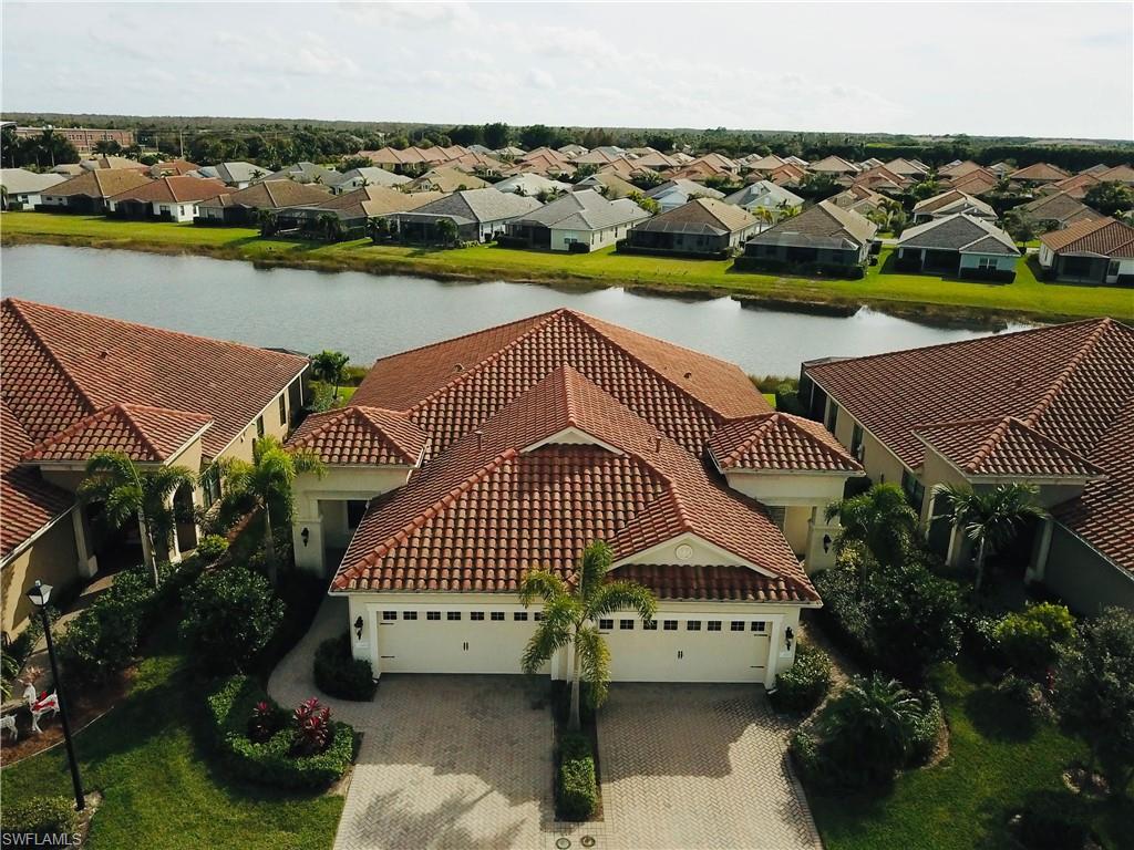 BEAUTIFUL VILLA IN THE GATED COMMUNITY OF WATERMARK. This vacation home villa, with 2 bedrooms, 2 baths, plus den, 2 car garage, 1,523 s. ft. villa offers a premiere lake view. Open floor plan featuring large diagonal tile floors, carpet in bedrooms, tile in bathes. Kitchen offers 42" cabinets with granite countertops, tiled backsplash, and island, under cabinet lighting, stainless steel appliances, tray ceiling, crown molding, sliding glass doors leading out to a screened extended lanai overlooking a peaceful lake-front view. Upgrades include, glass etched front door,  upgraded lighting and (4) fans, gas line hook-up for gas grill or fire pit, added lighting on lanai, French doors entering den and farm door in master bedroom.  Watermark is a NATUAL GAS community with low HOA fees and no CDD. This is living at its finest with a resort style pool, hot tub, fitness center, community screened cabana for parties, fire pit, basketball, tennis, playground, and even a Bark Park for your furry friends. All conveniently located just minutes from I-75, Southwest Florida International Airport, the beaches, shopping and restaurants. COME EXPERIENCE THE SW FL LIFESTYLE AT ITS FINEST.