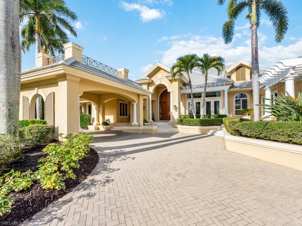 Beautiful custom built Harwick home w/ circular drive and porte cochere entrance.  As beautiful from the outside as on the inside!  Fantastic lake, golf, and sunset views from many of the rooms.  Fine finishes include ceiling treatments, extensive moldings and base boards, marble and wood flooring, impact glass windows and doors, new roof in 2022, tons of storage and more.  Inviting living room with fireplace, lovely dining room and stunning office. 4 ensuite private bedrooms and guest powder room.  Open family room and very spacious kitchen and wet bar as well as a wine room.  Oversized sunny laundry room and oversized 3 car garage. Gorgeous lanai with pool, spa, outdoor kitchen/bar, and lots of covered seating. Inviting private patio on side of kitchen. Primary suite w/its large his/her bath, closets and sitting room opens to the lanai. Wonderfully maintained home in most desirable Spring Ridge. in Enjoy the total lifestyle that this home offers, as well as Bonita Bay w/5 golf courses, private beach, marina, sports/racquet center w/resort pool, state of the art lifestyle center, spa, miles of biking and walking trails, and 3 parks.