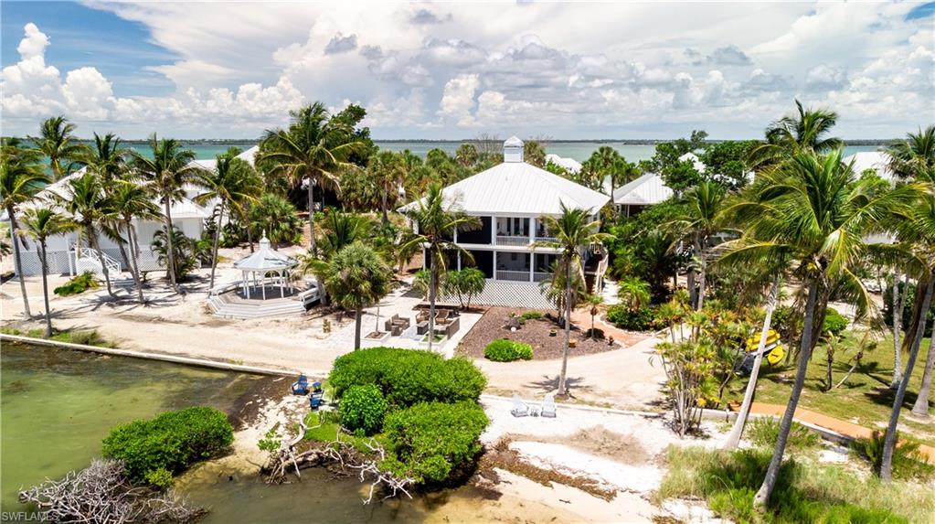 Situated on the northwestern point of Useppa Island, "Whelk Cottage" is a 2-bedroom, 2.5-bath townhome offering a warm ambiance with spectacular west-facing waterfront views. Once inside, your attention is drawn to the breathtaking waterscape stretching across the Intracoastal Waterway, where nightly sunsets provide a constant reminder that you are within a true Florida paradise. The shoreline is framed by mangroves, with surrounding tropical greenery reminiscent of the world's most sought-after island destinations. For lovers of wildlife, the setting is exceptional, with frequent sightings of dolphins, manatees and fish in the surrounding waters. Bird enthusiasts will delight in the abundance of wading birds, songbirds, and birds of prey that call the island home. Whelk Cottage offers an authentic and immersive Florida island lifestyle.

The villa features two en-suite bedrooms on the main living level, each with convenient access to outdoor space. The western bedroom serves as the primary suite and includes a spacious bath with dual sinks, a large tiled shower, and a walk-in closet. Impact-rated French doors open to a screened porch overlooking the water to the west, offering a more private setting to soak in the pristine views. The eastern bedroom is currently utilized as a den, complete with a full bath and ample closet storage. It offers direct access to an open wrap-around deck surrounded by verdant palms and tropical plantings, creating a tranquil setting of lush greenery.

The upper level is dedicated entirely to the living and dining areas, where the cottage's most spectacular elevated water views are fully showcased. Its classic island finishes include crisp whites with splashes of tropical color and warm natural wood details throughout. The kitchen is well suited for everything from intimate dinners for two to entertaining guests for a sunset gathering. The living room features a vaulted wood-beam ceiling that adds warmth and character to the space, while a gas fireplace enhances the inviting atmosphere. Few experiences compare to enjoying a cool winter evening on a Florida island with a fire glowing indoors and expansive waterfront views just beyond the windows.

For the past 30 years, Whelk Cottage has been lovingly maintained as a full-time residence and treasured family retreat. Continuous care and thoughtful updates include a new roof (2023), impact-rated windows and doors, roll-down hurricane screens (2024), HVAC system (2024), and water heater (2024). Its location on the northwestern tip of Useppa Island provides a peaceful setting with world-class views while remaining conveniently close to dockage at the Useppa Marina. Ownership includes the deeded right to dock a boat up to 24 feet in length at the marina, a valuable amenity that further enhances the island lifestyle. "Whelk Cottage" offers an opportunity to own a well-maintained and appointed waterfront retreat within one of Florida's most exclusive island communities.