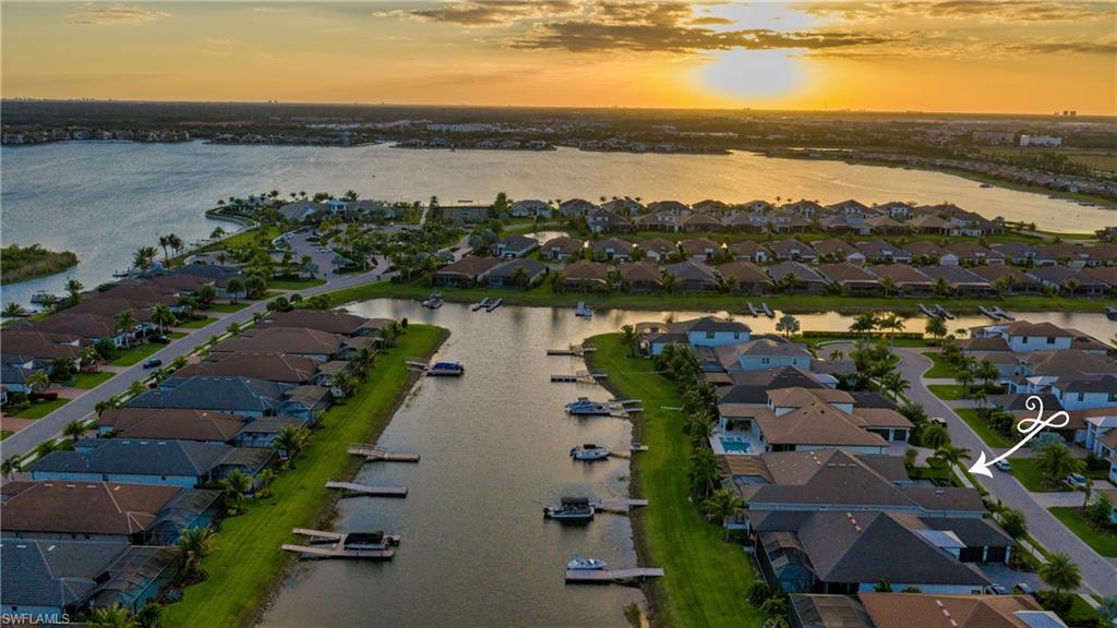 Exceptional waterfront living is yours in this designer residence situated on a southern facing estate homesite in Esplanade Lake Club with private boat dock. Every detail of this home has been thoughtfully selected for luxury and livability. Spanning over 3,300 air-conditioned square feet with 3 en suite bedrooms plus a dedicated home office and air-conditioned 3-car garage, this expansive Beacon floorplan is no longer being built. The striking timeless interiors of this great room floorplan include carefully curated, designer lighting, thoughtful architectural ceiling details, 8.75” baseboards, 12-foot ceilings, crown molding, window treatments, motorized shades, a new custom iron cantilever front door, custom interior doors, new wide-plank flooring, and distinctive tile work throughout. The primary bedroom is adjacent to the dedicated home office. This private sanctuary offers spacious customized his and her walk-in closets, a spa-like bathroom with dual sinks, large walk-in shower and separate water closet. Two additional guest suites feature walk-in closets and en suite baths. The great room with natural gas fireplace flows to the chef's kitchen with professional grade natural gas cooktop, dual ovens, built-in refrigerator, custom walk-in pantry and large center island and eat-in dining area overlooking the lake. The design provides a seamless indoor-outdoor flow for perfect Florida living. The incredible outdoor living complemented by stunning lake views nearly doubles the living space for entertaining and family enjoyment. Take a sunset cruise from your back yard dock and return to the ambiance of the linear fire feature adjacent to the outdoor living room or gather for a poolside dinner in the gracious outdoor kitchen and dining area. The custom pool features a sun-shelf, spa, water features and an expanded concrete set natural stone pool deck.  A boater's paradise, the property includes a deeded dock with electric and water, whole house generator, motorized roll-down hurricane screens and privacy screens, tankless hot water heater and whole house Kinetico soft water system with kitchen reverse osmosis. The beautifully curated furniture package featuring primarily Restoration Hardware pieces is available for separate purchase. Designed to reflect modern elegance and timeless style, the collection includes high-end materials, statement pieces, and a cohesive aesthetic throughout. Each space has been thoughtfully styled to create a polished, move-in-ready home. A rare opportunity to enjoy a designer-furnished residence without the time or expense of sourcing premium furnishings. Globally sourced artwork adds a distinctive, curated touch throughout the home. Welcome to your Florida Oasis!