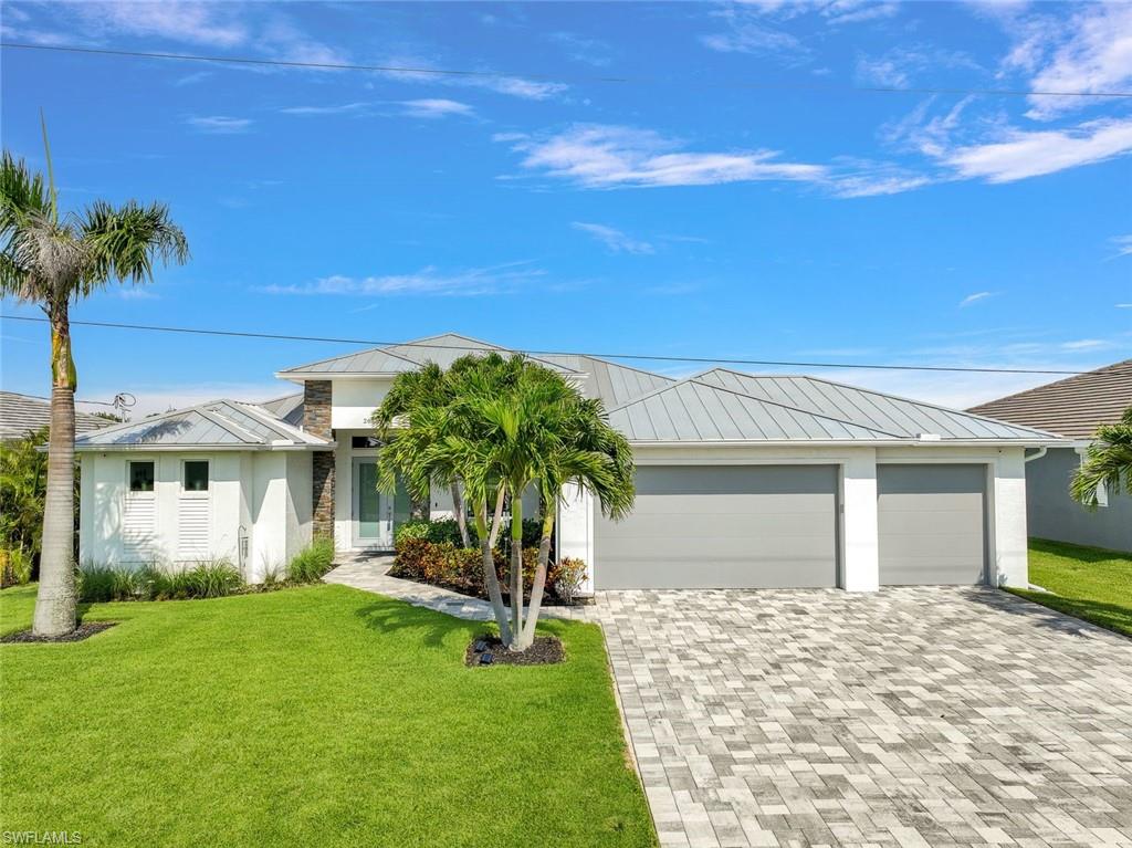 Stunning contemporary Gulf Access newer home in SW Cape Coral.  Modern Luxury loaded with upgrades throughout and featuring 4 bed 3 full bath and large 3 car garage. Open living room with feature wall and fireplace, large sliders overlooking the pool and water. Entertainer’s kitchen with custom lighting, waterfall edge center island, professional café range, induction cooktop, upgraded fridge, and two-tone cabinets w/ inner lit cabinets. Master suite with water views enjoys a resort style bathroom with dual vanity, modern tub, and walk-in zero entry steam shower. Waterfront junior master suite with full en-suite bathroom. Large spare bedrooms w/ walk-in closets. Luxury tiles, accent lighting, and camera system, smart lighting, metal roof, UV water filtration, and more! Entertain & relax poolside in the private and modern pool & lanai. Picture window screens, lush landscaping, outdoor shower, heated pool, and water emitters. Outdoor kitchen & beverage cooler. Western Exposure for amazing sunsets and lots of daytime sunlight on the pool. Boating? Enjoy boating directly from the backyard. Home is located near shopping, restaurants, and medical facilities. Upgrade List attached to MLS.