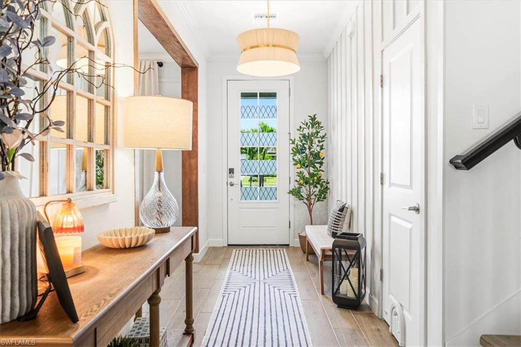 Tucked into the vibrant Verdana Village community, this exquisitely upgraded Amalfi model at 18656 Ives Drive proves you don't have to wait to build to own something truly special. With 4 bedrooms, a versatile upstairs loft, 3 full baths, and 2,606 square feet of impeccably finished living space, every inch tells a story of thoughtful craftsmanship. The current owners spared no detail. Custom wood-detail walls grace the entry, dining room, office, loft, and primary suite, while crown molding wraps the entire first floor. A striking entertainment build-out anchors the main living room with floating shelves and a fireplace, echoed by a second feature wall in the loft. The kitchen impresses with a gas range, quartz counters, abundant cabinetry, custom backsplash, and a shiplap-wrapped island, complemented by a stylish coffee bar with wine fridge. Carpet has been eliminated throughout—including the staircase—and matte black hardware ties the palette together. Just outside is a fully enclosed pool and spa retreat featuring color-changing LEDs, a tongue-and-groove wood lanai ceiling, and a custom outdoor fireplace built for evening gatherings. Fresh exterior paint, upgraded lighting, sealed pavers, and lush new landscaping complete the picture. Impact glass windows deliver peace of mind through any storm. Three bedrooms reside upstairs alongside the loft, while a fourth bedroom on the main level offers flexibility for guests. The location is equally compelling. Publix at The Shoppes at Verdana Village sits less than a mile away, with Miromar Outlets, Gulf Coast Town Center and Southwest Florida International Airport within a short drive. Residents enjoy a remarkable amenity center boasting an indoor sports complex with tennis, pickleball, and basketball, plus a fitness center and resort-style pool. This is move-in-ready Estero living, elevated by uncommon quality and finished with genuine care.