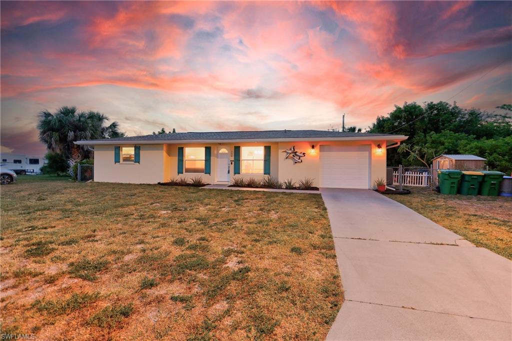 This charming 2-bedroom, 2-bathroom, 1-car garage home is situated on a quiet street with no neighbors on either side, offering a level of privacy that is rare for the area. This home has never flooded and includes hurricane shutters, providing essential protection and confidence. The interior is move-in ready and features easy-to-maintain tile flooring throughout the entire home, along with a versatile Florida room that provides a bright and peaceful space to relax. The kitchen has been fully transformed with white shaker cabinets, quartz countertops, a subway tile backsplash, and stainless appliances. The primary bathroom is a designer standout, featuring boutique-style fish scale tile, a vessel sink, and a quartz vanity. The oversized, fully fenced lot is an outdoor retreat, complete with a shaded lounge area with string lights and a mature tropical "food forest" including three varieties of mango, mulberry, Jamaican cherry, hog plum, banana, and avocado. Buyers will have ultimate peace of mind thanks to significant upgrades including a new roof and gutters, a new Lennox Elite A/C system with new ductwork and blown-in insulation, a new electrical panel, new exterior doors, and windows. Located near local boat ramps,  Gulf beaches, shopping, and a brand-new park at the end of the block, this meticulously cared-for property is the perfect turnkey Florida retreat. Schedule your showing today!