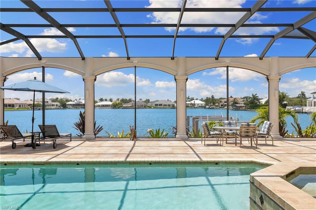 Indulge in the epitome of luxury living with this magnificent 5 bedroom, 8 bathroom, over 4,800 square foot home, situated on a serene bay with sought-after western exposure. This impressive property features a fully fenced lot, complete with two motorized boat lifts, a new seawall, and a 2018 roof. Upon entering, you'll be greeted by high ceilings, marble floors, and an abundance of natural light streaming in through the oversized sliding glass doors directly overlooking the bay. The architectural elements include built-ins, crown mouldings, decorative mouldings, and a sound system throughout the home. The master suite beckons with two renovated bathrooms, offering a private retreat of unparalleled comfort and style and direct ocean views right from your bedroom. With a wet bar and GE Cafe wine-fridge, the master bedroom is a wing all of it's own. While the guest wing on the North side of the home offers a separate oasis with 4 bedrooms and 4 ensuite bathrooms, nestled away behind a pocket door. The chef's kitchen is a culinary delight, featuring granite countertops, stainless steel high-end appliances, Wolf double oven's, and a sleek island with electric stove-top. The formal dining room, foyer, and home office provide ample space for both entertaining and productivity. Step outside to enjoy the western exposure and breathtaking water views from the private fenced back yard, and spacious patio. The pool and hot tub are perfect for relaxation and entertaining. Don't miss the opportunity to make this exquisite property your new home. Schedule a showing today and experience the epitome of luxury living in Marco Island.