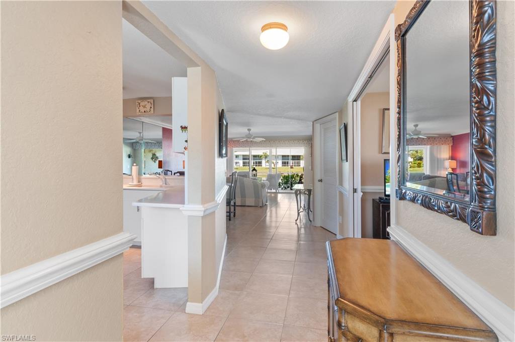 This light and bright end unit 1st floor condo has been lovingly maintained with updates in the Kitchen and baths. 
Primary bath boasts updated granite double sinks and a walk-in shower.  Spacious kitchen has newer appliances - Stove, microwave, refrigerator and dishwasher.  Granite counters in the kitchen offer plenty of counter space and extends into the dining room and serves as a bar area.  Condo is furnished and turnkey so you just need your suitcase!  A/C system replaced 2021. Den has a full closet and can be used as a 3rd bedroom. Dining room and living room look out to the view of the lanai and lake. Tiled floors in lanai area for easy maintenance.  Ceramic tile floors with exception of wooden laminate flooring in bedrooms. End unit offers an additional window in the den. The community offers many activities including a shuffleboard, bocce, tennis and pickleball. 4 community pools to pick from! Conveniently located near shopping and only 5 miles to Old Naples and the beach.