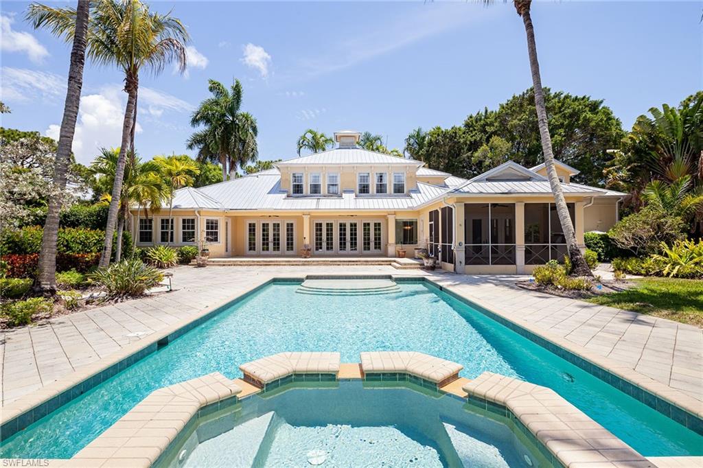 The ultimate Naples lifestyle with land and privacy within 1.6 miles of Seagate Beach access to the white sands of the Gulf of Mexico. Situated within the prestigious, award-winning, top neighborhood in the U.S. Pine Ridge, on a lush tropical 1.3-acre lot. This charming home offers character and could easily be given a modern twist. Featuring 6 bedrooms with 5 having en suites and a very generous primary suite on the first level. Upon entering this estate home, you have spacious entertainment areas with a bar area that overlooks the long, extended pool and spa. The open kitchen with breakfast bar and great room provide an additional family living area, along with a formal dining room, office and media room. The living area extends outdoors to the screened-in summer kitchen, tennis court and tiki hut. The corner lot provides tremendous curb appeal for guests to enter on Ridge Drive and side driveway off Caribbean Road to your private drive with 3-car garage. Your location is impeccable, with Waterside Shops across the street and Mercato nearby. This truly could be created into a family compound and offer a private life in the middle of paradise, Naples!