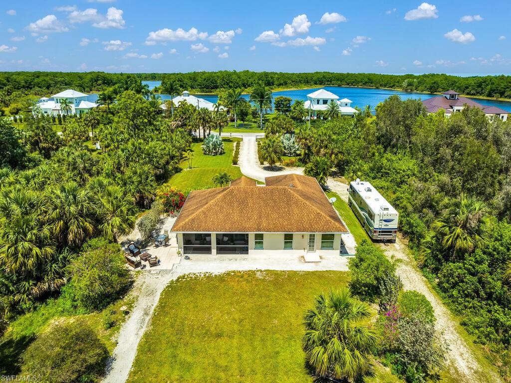 Enjoy this nature lovers paradise set on 1.59 acres in Golden Gate Estates.  This unique location is opposite multi million dollar homes on Shady Hollow with views of the 150 acre lake. The lot has been selectively cleared making a beautiful park like setting perfect for playing, horses, or just relaxing under the shade of the mature Florida Oaks.  The home boasts beautiful finishes including porcelain and laminate floors throughout, custom trim work, whole home reverse osmosis system, a gated entry, custom kitchen cabinets and a large island, a large walk in shower in the primary bedroom, and a jacuzzi tub in the guest bathroom. The location of this home offers lots of activities close by including the Crew Bird Rookery Swamp Trail with over 12 miles of hiking and biking trails on the same street as the property, a quick five minute drive to the new Big Corkscrew Island Regional Park and Aquatic Center, and 10 minutes to Audubon Corkscrew Swamp Sanctuary. This home is also located just minutes to Publix, Founder Square restaurants, and the new commercial space coming to the Randall curve.