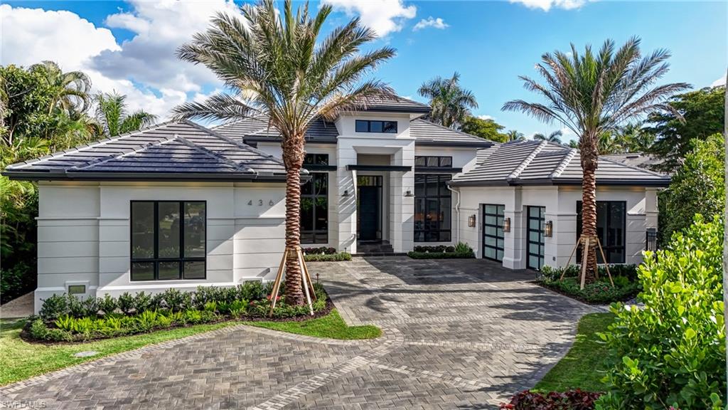 Introducing an extraordinary new construction estate in The Moorings—crafted by Borelli Construction, one of Naples’ longest-standing family-owned luxury builders. Designed by Unique Hite Designs with interiors and furnishings by R & Co. Designs, this single-level residence offers 5,156 square feet of impeccably curated living space on nearly a half-acre cul-de-sac homesite. A sense of arrival begins before entering the home, where custom water features and lush landscaping create a serene first impression. Inside, the home showcases European wide-plank white oak flooring, Samsung Frame TVs, Crestron Home automation, and a level of bespoke detail rarely found—every space thoughtfully layered with custom wall treatments, woodwork, or lighting selections. The floor plan features five en-suite bedrooms with fully built-out closets, plus a stunning home office wrapped in bleached walnut millwork with integrated LED lighting. The chef’s kitchen centers around a book-matched quartzite stone island with waterfall edges and includes a 60" Wolf range with double griddle, full Sub-Zero refrigeration, a full-size wine column, and a butler’s pantry equipped with additional Wolf appliances. The primary suite is a private retreat with a sitting room overlooking the pool and tranquil backyard. Designer window treatments include hardwired, Crestron-integrated shades throughout. The outdoor living experience is exceptional. An oversized pool and spa with custom pebble finish, sun shelf with in-water loungers, expansive grassy yard, and a massive outdoor kitchen in the covered lanai, protected by retractable screens and hurricane shutters, create the perfect setting for relaxation and entertaining. Additional features include three garage spaces plus a dedicated golf cart garage, thoughtful storage, and a location moments from The Moorings Golf & Country Club and minutes to downtown Naples. A rare offering with unmatched craftsmanship and design—this home is truly one of one and an absolute must-see.