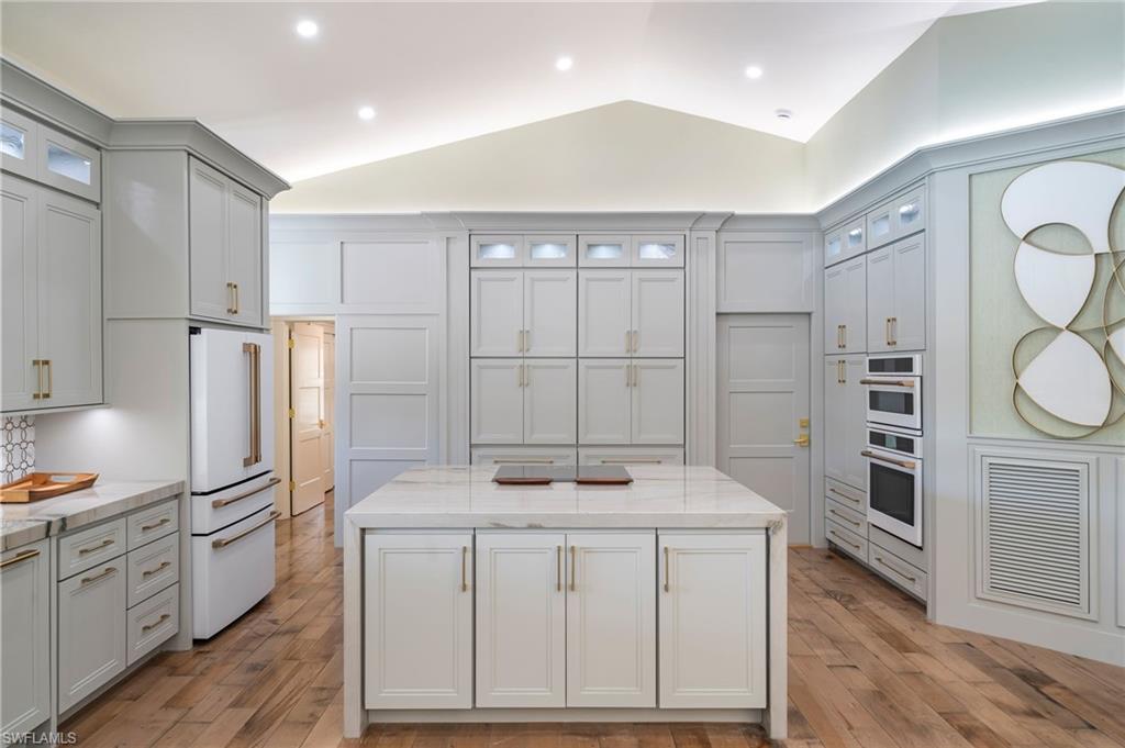 Perfectly positioned at the end of a quiet cul-de-sac on an extraordinary 190+ foot lakefront lot, this single-family “JEWEL BOX GEM” in Pelican Bay has been completely reimagined to deliver exceptional design, craftsmanship, and modern technology rarely found in today’s market. Wide plank distressed wood floors, 8” baseboards, custom casement detailing, skylights, and Lutron lighting enhance the home throughout. The vaulted great room is a showpiece, featuring a built-in media wall with glass shelving and a NetZero linear fireplace. The gourmet kitchen is thoughtfully designed with Macaubas Fantasy Quartzite countertops, marble and satin brass backsplash, custom cabinetry with glass display uppers, BLANCO sink, Monogram Café appliances, Zephyr downdraft vent, and Bosch dishwasher, while the adjacent dining area offers vaulted ceilings, a custom buffet, and French doors. A spacious private den/office with frosted glass doors, bay window, and custom built-ins provides flexibility. The owner’s retreat features vaulted ceilings and refined detailing, leading to a spa-inspired bath with dual sinks, Riobel fixtures, Quartzite surfaces, a walk-in shower with rain head, and a freestanding soaking tub with garden views. The guest wing offers two well-appointed suites with custom closets, plantation shutters, and detailed millwork, along with a guest bath showcasing Essenza Blue Quartzite and a walk-in shower with mosaic pebble flooring. The finished garage mirrors the home’s quality with porcelain flooring, custom cabinetry, split AC, and a fully built-out laundry with quartzite counters, BLANCO sink, and Samsung Bespoke refrigerator and washer/dryer. Outdoors, enjoy a private resort setting with a covered lanai, motorized screens, summer kitchen with Napoleon grill, crema marble decking, full pool bath with shower,  refinished pool and spa with mosaic tiling, fire pit area, patio, large fenced yard and serene lake views enhanced by a lakefront fountain and lushly landscaped flowering plantings and mature trees.  Walkways, LED landscape lighting privacy wall accents and pebbled rock gardens all enrich the hardscape. Pelican Bay residents enjoy private beach access with dining and tram service. The amenity rich lifestyle at Pelican Bay offers tennis, pickleball, fitness center, community center activities  Bike lanes, walking paths, sidewalks and community events, art classes, and so much more—offering the ultimate Naples coastal lifestyle. Minutes to luxury shopping and dining at Waterside Shops, Olde Naples and a large array of cultural events at Artis Naples Seize the rare opportunity to own a completely reimagined residence—featuring a new roof, impact windows and doors, and fully updated mechanical, electrical, lighting, and advanced technology systems—delivering unmatched peace of mind, modern luxury, and a level of turnkey living that is simply impossible to replicate at this price point.
